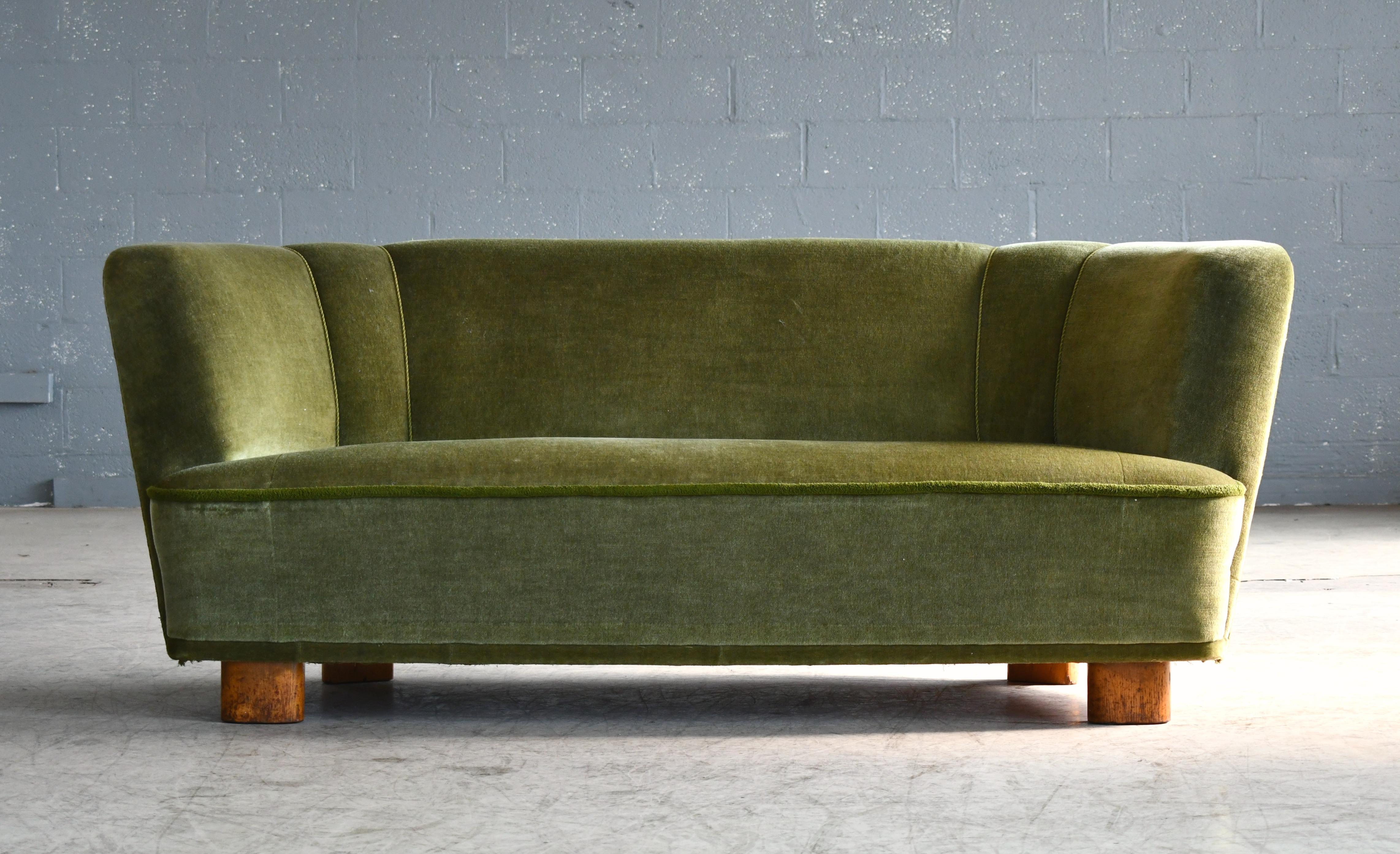 Beautiful and very elegant 1940s curved three-seat sofa in green velvet fabric. The sofa has springs in the seat and the backrest and the cushions are nice and firm and the sofa very sturdy. The sofa has been re-upholstered in the past and the green
