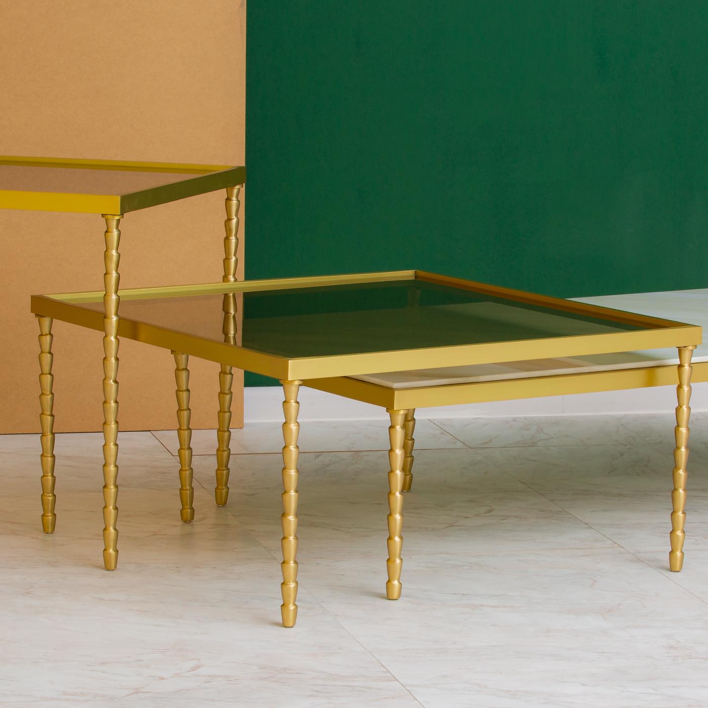 Either alone, as a central decoration in a modern living room, or paired with the Banano side table for a dynamic effect, this coffee table will make a statement in a sophisticated interior. It was entirely handmade and customizable. Its solid brass
