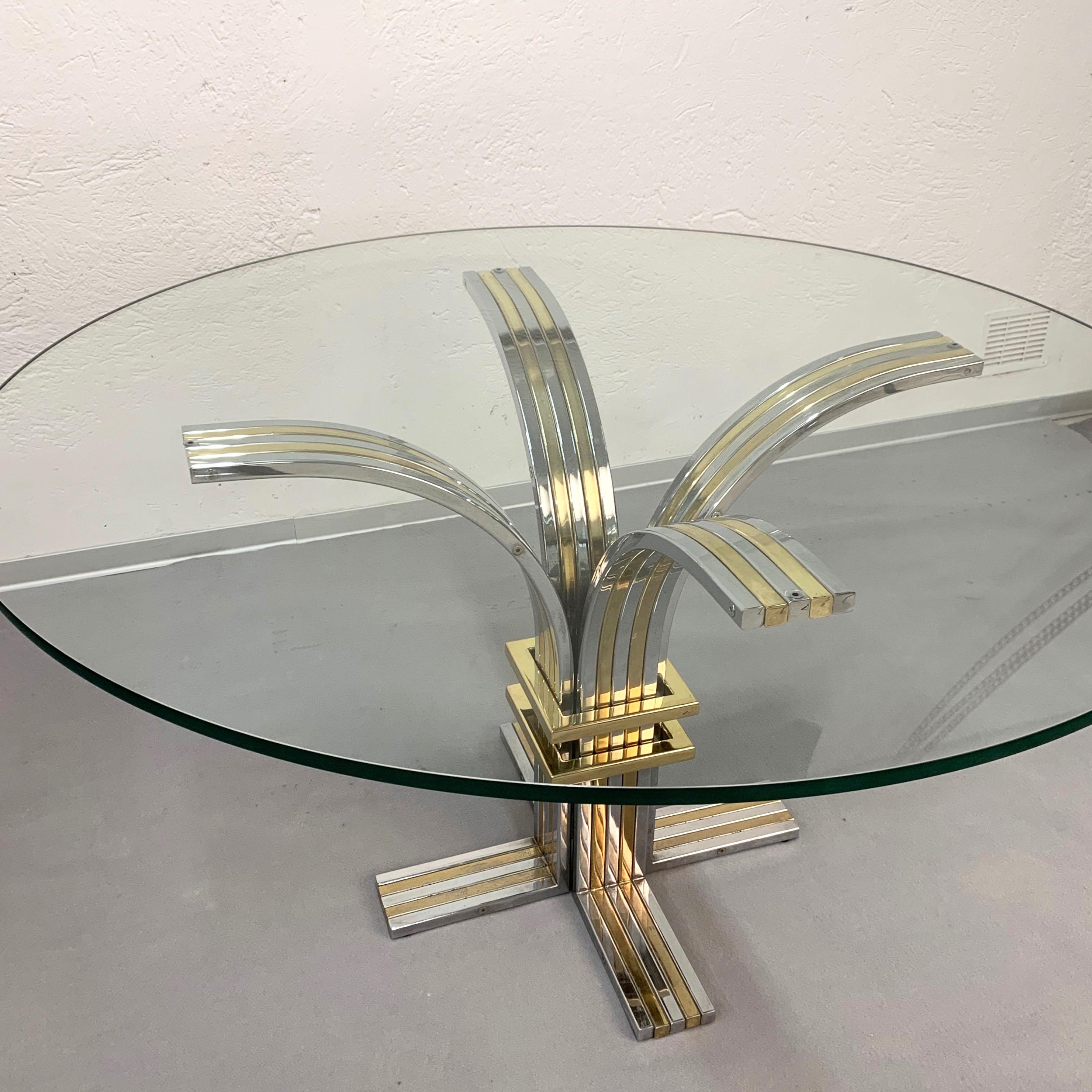 Banci and Firenze midcentury gilded brass and chromed Italian dining table 1970s

The brass and chromed structure bloom in four sides like a flower, with a horizontal element made of brass too. The top is a very thick, 15 mm, piece of glass, that