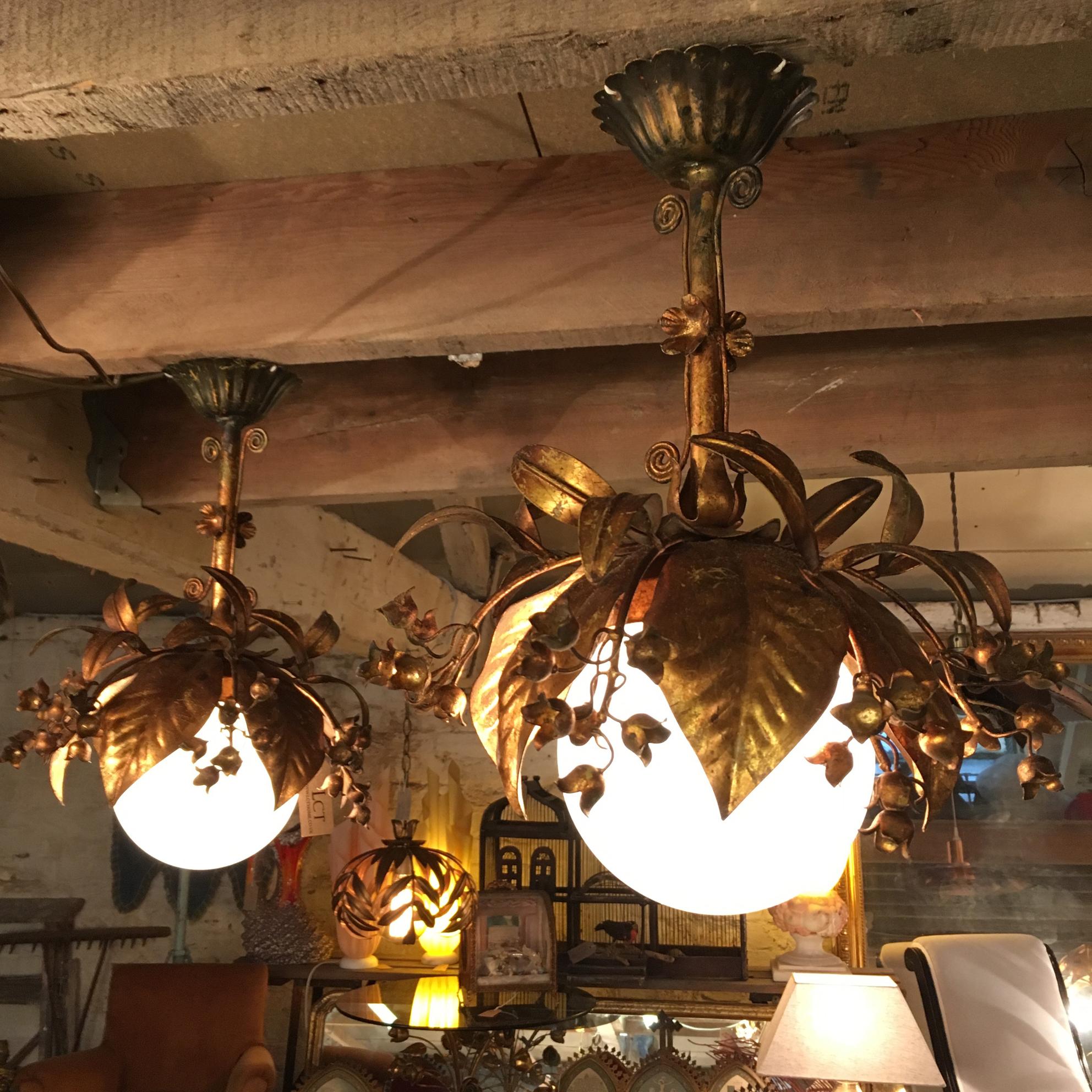 Beautiful pair of Banci Firenze gilt globe pendant lights, 

Italy, 

1950s

Gilt leaves and flowers surround a 15cm milk glass globe

Twisted decorative details form the stem along with more flowers

The lights are fixed to scalloped