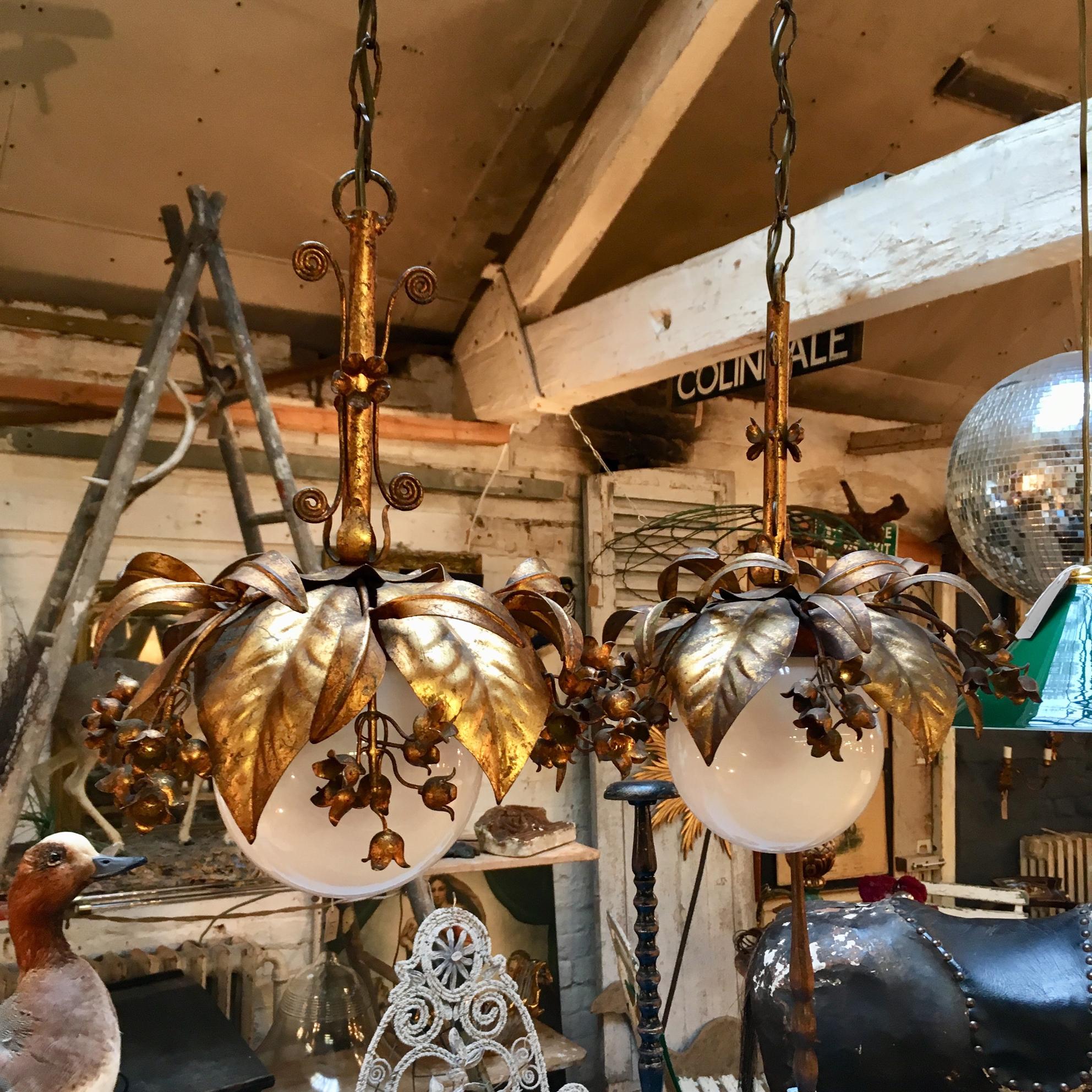 Beautiful pair of Banci Firenze hanging globe pendant lights,

Italy,

1950s

Gilt leaves and flowers surround a 15 cm milk glass globe

Twisted decorative details form the stem along with more flowers

The lights hang from long chains