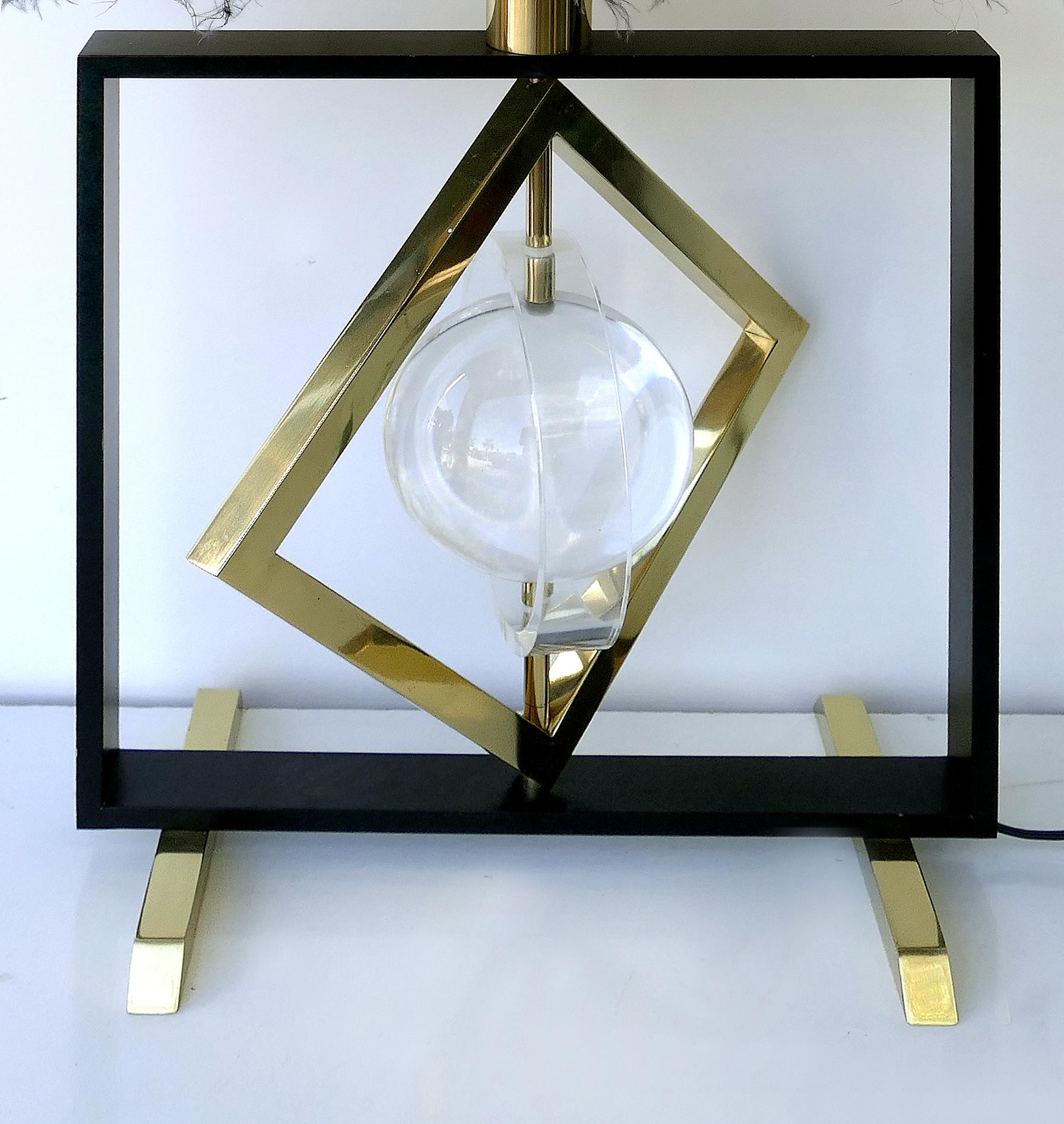 Banci sculptural kinetic table lamp with original shade.

Offered for sale is a stunning sculptural Italian 1980s table lamp attributed to Banci. The lamp has a kinetic brass diamond-shaped ring and a Lucite round ring that both rotate around a
