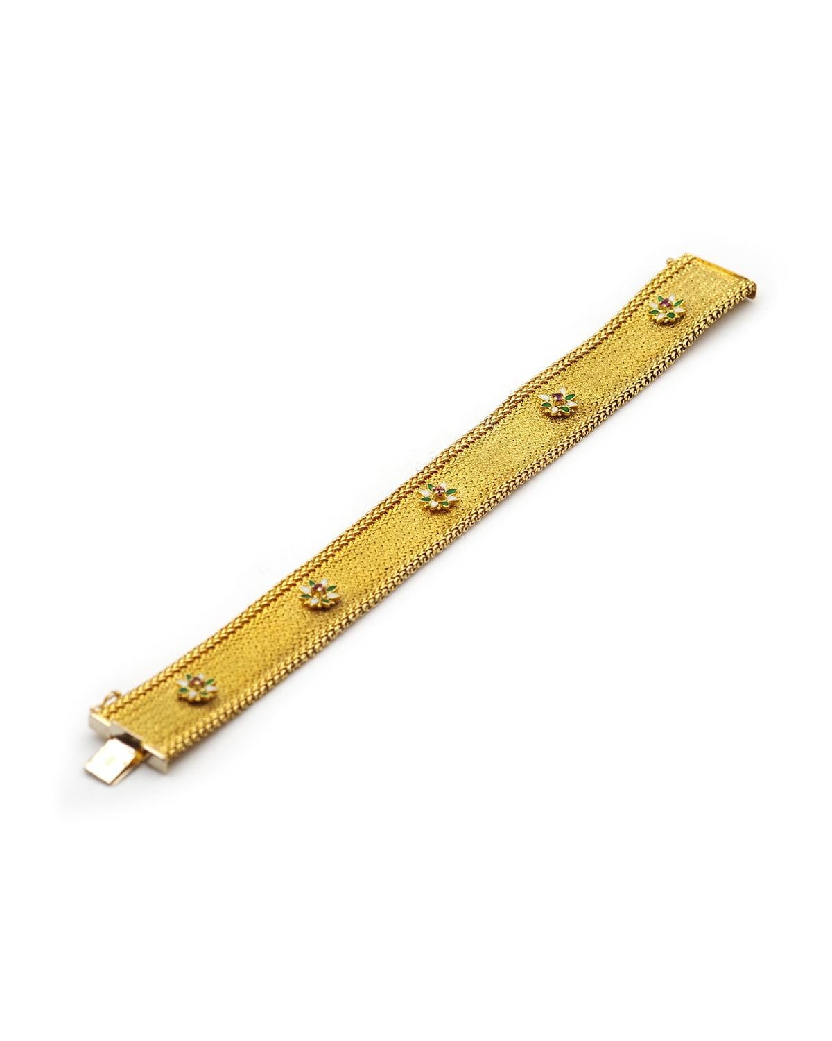 Bracelet UnoAErre à bandes fleuries en or 18 carats. Un bracelet des années 1970, formant une bande souple en maille d'or, texturée au centre et tressée aux extrémités.
Elle est ornée de cinq fleurs aux pétales émaillés blanc et vert, chacune sertie