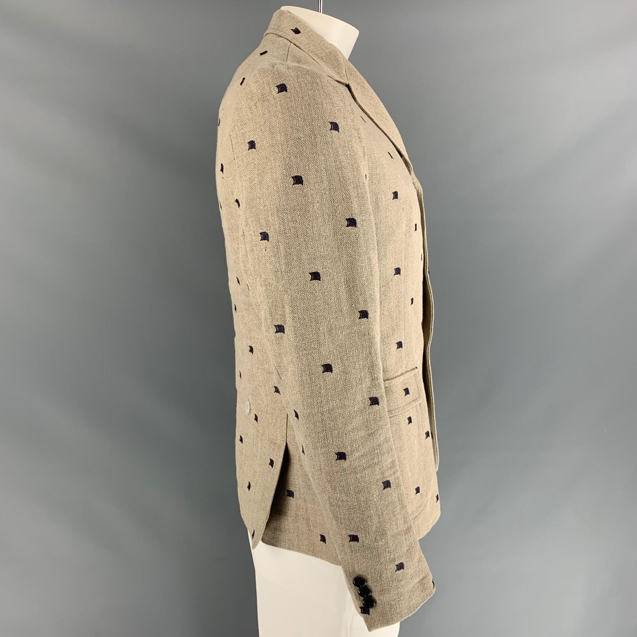 BAND OF OUTSIDERS sport coat comes in oatmeal and navy with flags print embroidery featuring a three button closure, straight no flap pockets, and notch lapel. Made in Italy.Excellent Pre-Owned Condition.
  

Marked:   3 

Measurements: 
 
Shoulder: