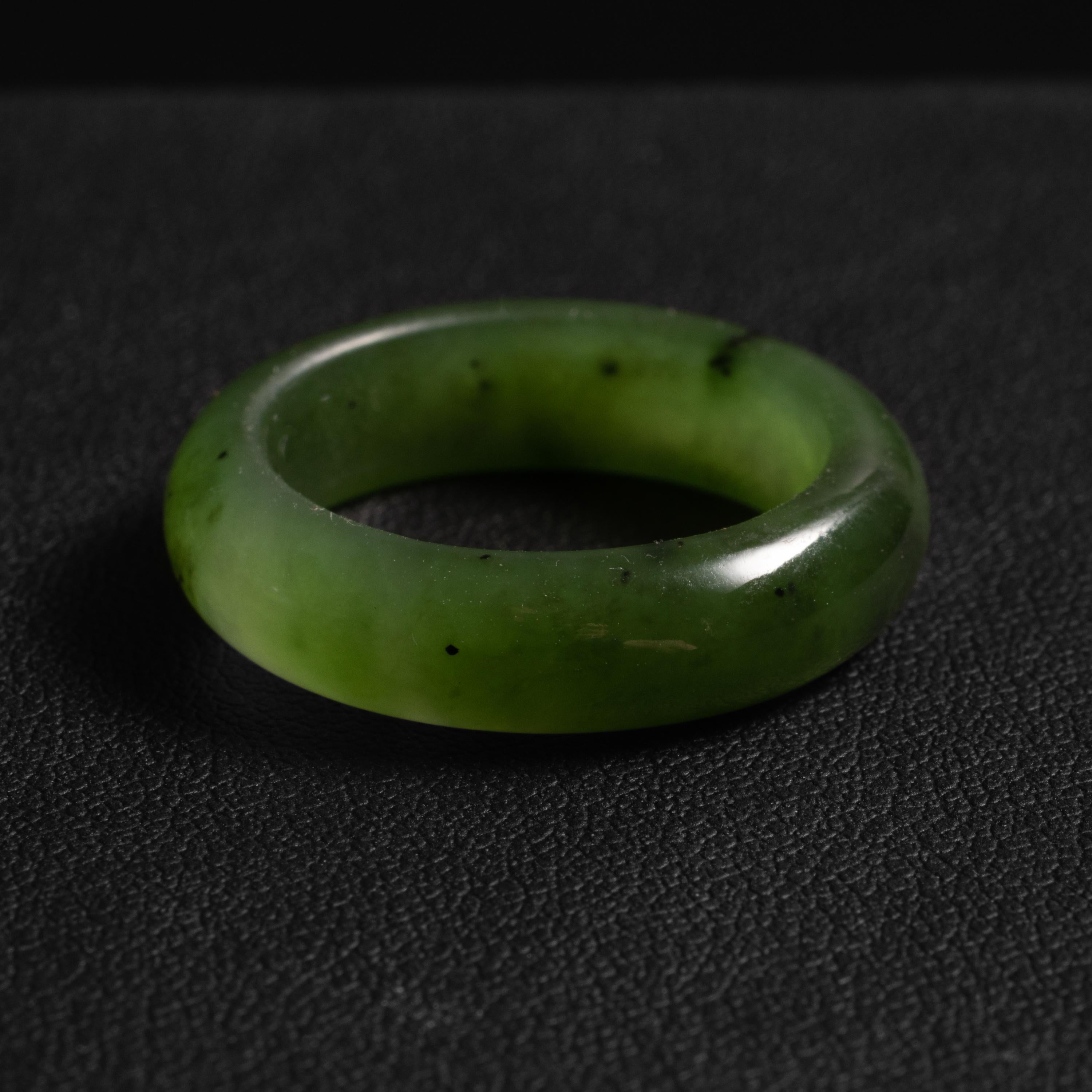This translucent olive-green band ring was hand-carved from natural and untreated nephrite jade.  The ring is a size 8 ¾. 

The luminous band has a high-polish outside, a matt-finish on the interior. It's a very comfortable ring to wear and because
