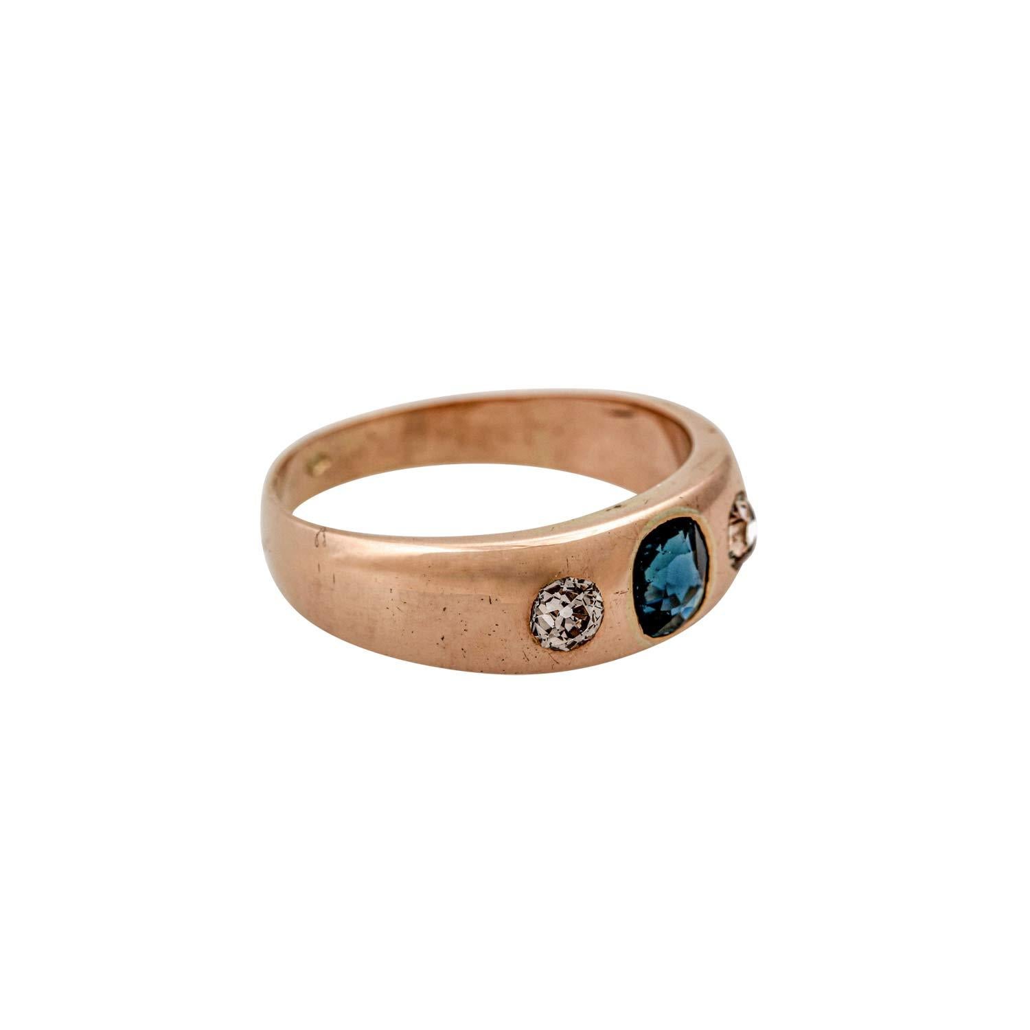 Band ring with an oval faceted sapphire and 2 old European cut diamonds, total approx. 0.3 ct, medium low quality, 14K rose gold, RW: 56, Austria around 1900, signs of wear, sapphire and 1 diamond chipped and scratched.
