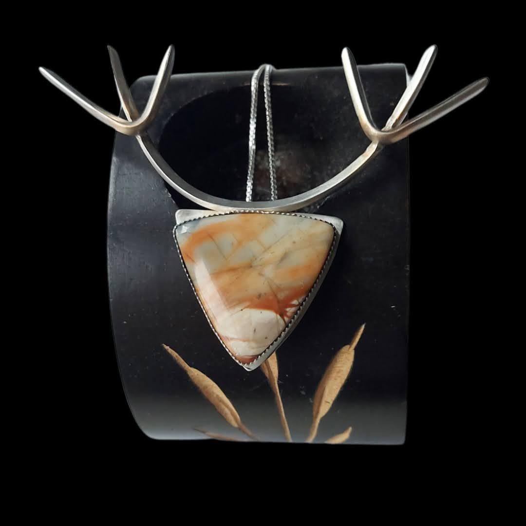 One-of-a-kind Banded Agate Silver Stag Pendant, crafted from sterling silver. silver-filled wire and a hand-cut gemstone, is definitely a statement piece. The design of the silver stag renders a strong and powerful symbol that evokes admiration, awe