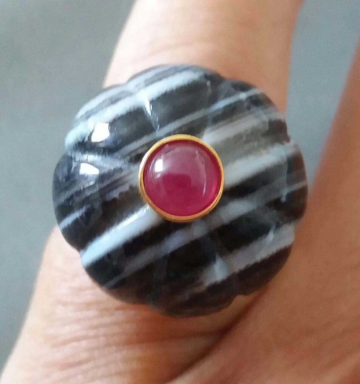  Banded Black Onix melon cut Round Bead of 20 mm. in diameter and 16 mm. thick with in the center a round Ruby cabochon of 6 mm. in diameter set in solid 14 kt yellow gold is mounted on top of a 14 Kt. yellow gold shank ( actual size #7, but can