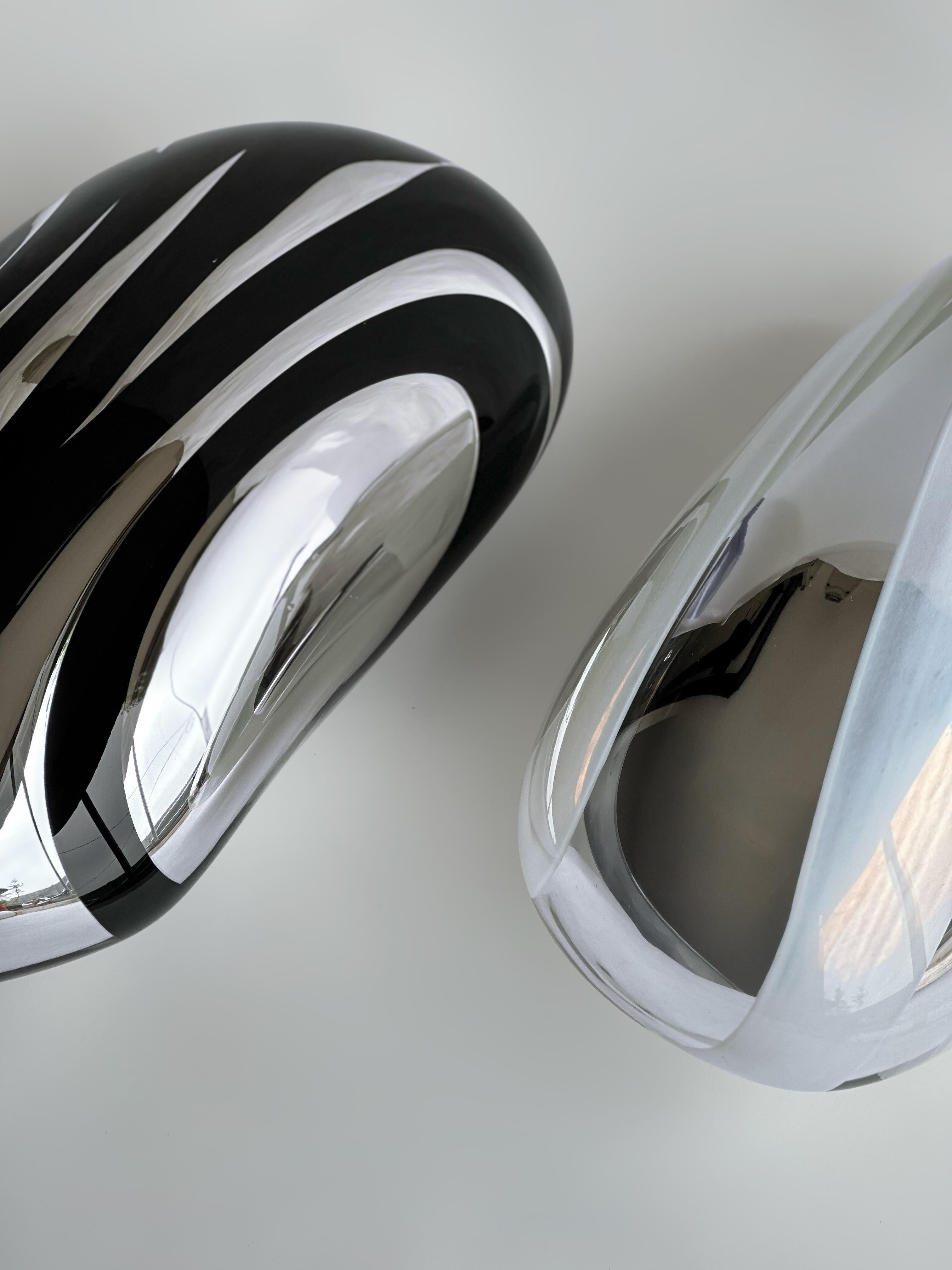 Vetro soffiato. Silver Mirror. 
43 x 21 x 19 cm  Colore: Argento e Bianco

LINE: Il processo di rispecchiamento è intrinsecamente multistrato e la Collection's LINE lo cattura magnificamente. Con il gioco di linee trasparenti e riflettenti, mostra