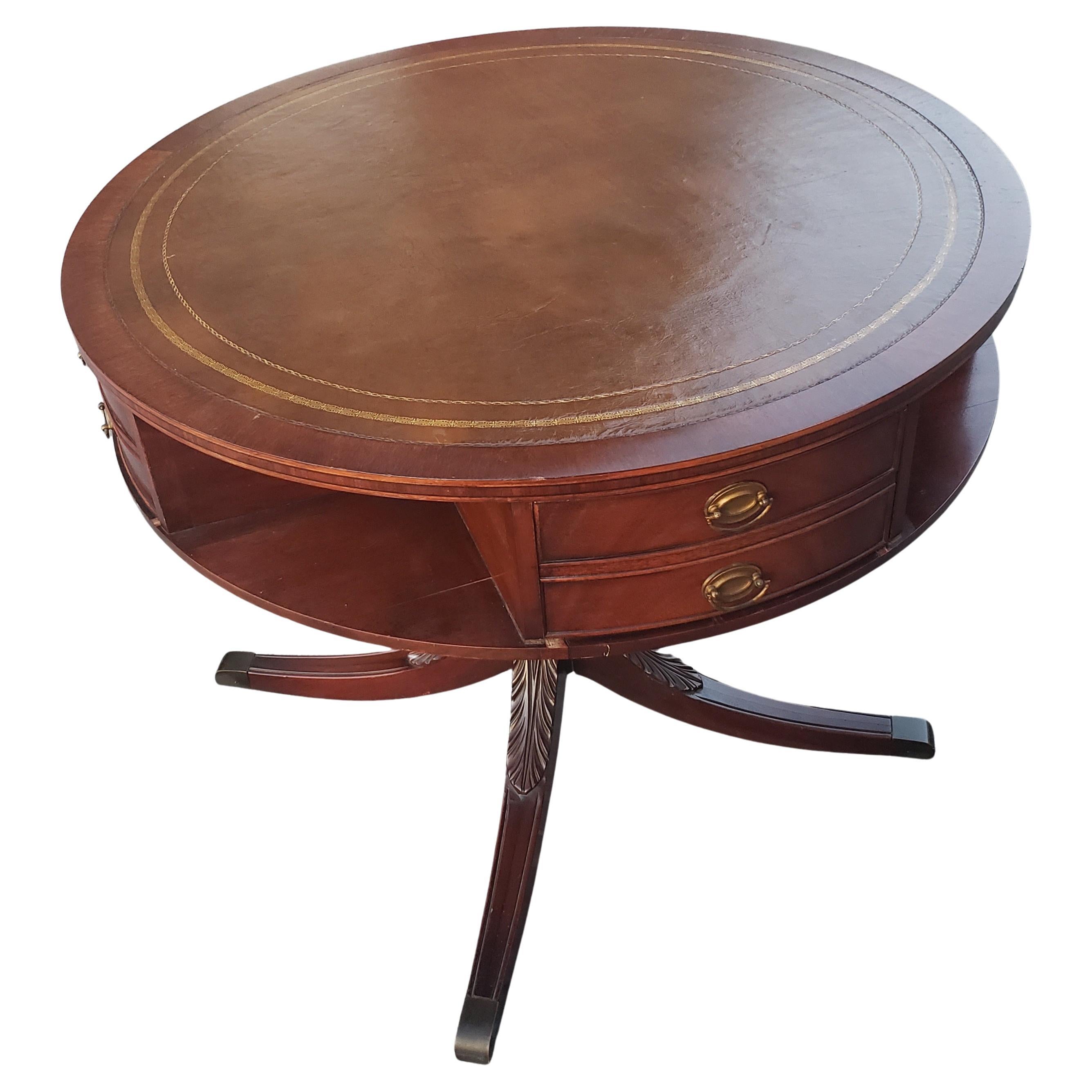 Banded Leather and stenciled Top Double Drum 4-drawer Mahogany Center Table, Circa 1940s.
All 4 dovetailed drawers working perfectly. Very deep drawers. A lot of storage. Very leather and stenciled top. 
Quad feet carved pedestal.

W7060522F.