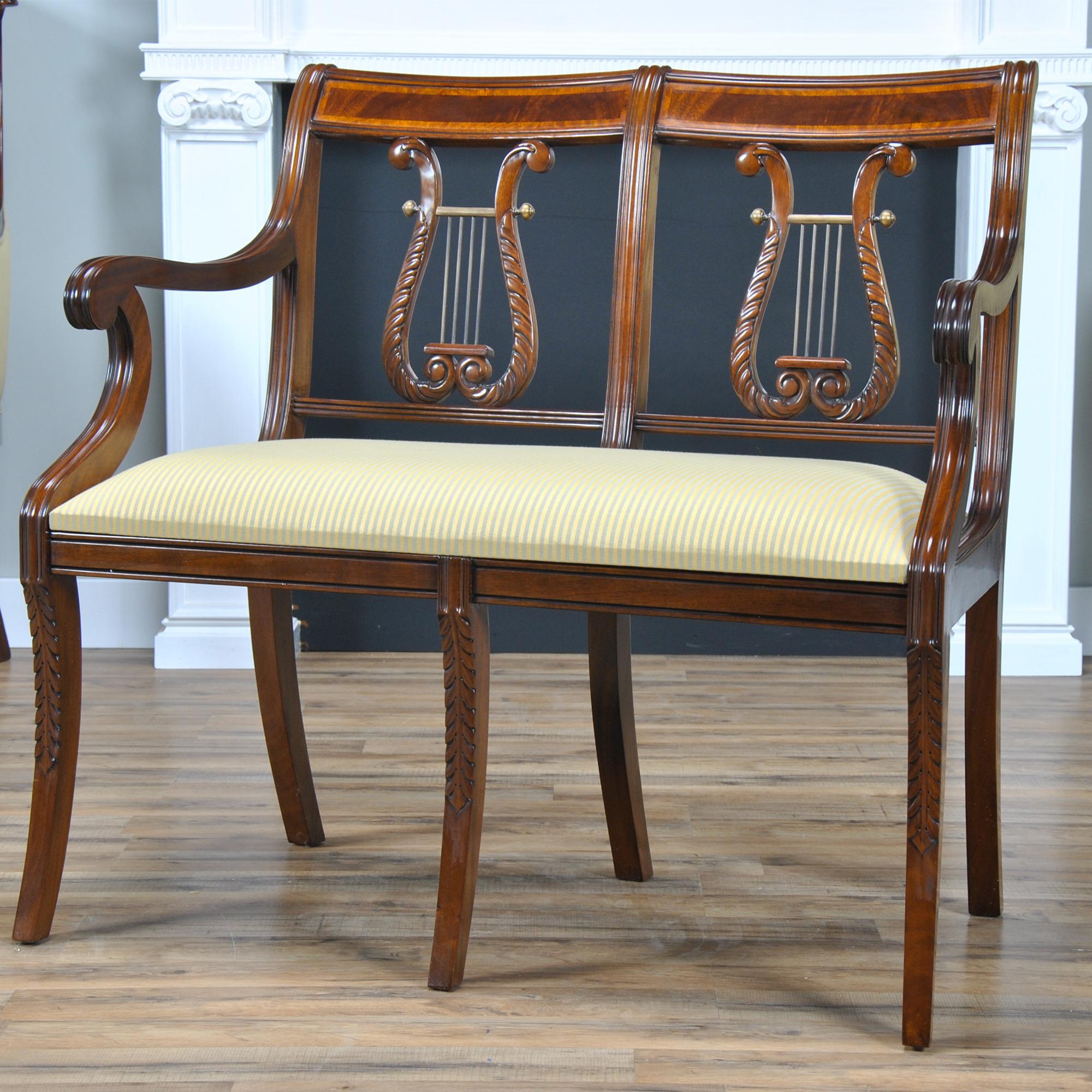 A fine quality, hand carved, solid mahogany Banded Lyre Back Two Seat Chair. Features include a figural mahogany crest rail surrounded by satinwood banding, lyre carved back splat with brass decorations, and legs featuring federal style carvings