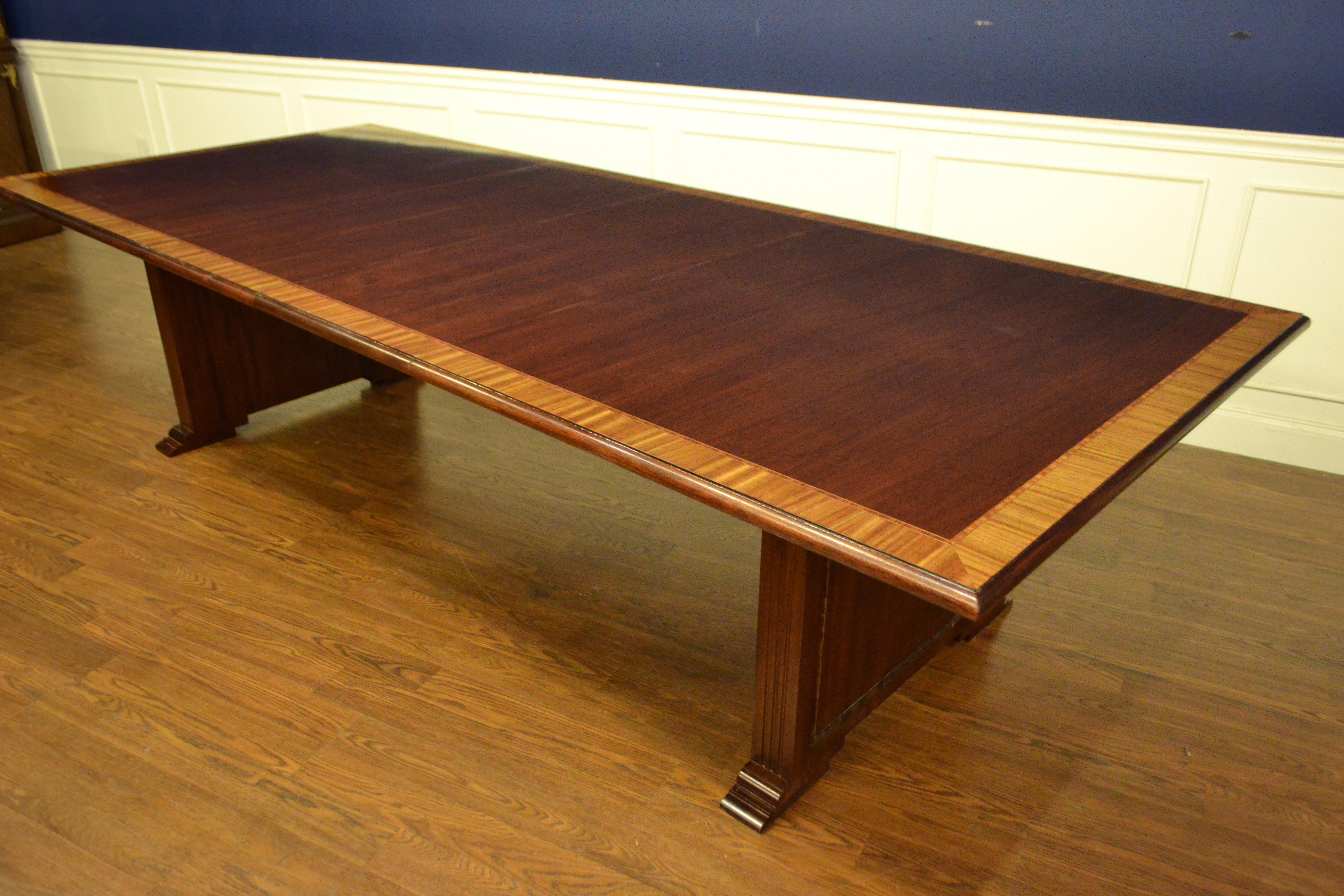 This is a made-to-order mahogany conference table made in the Leighton Hall shop. It features a field of ribbon mahogany and a satinwood border. It has two 