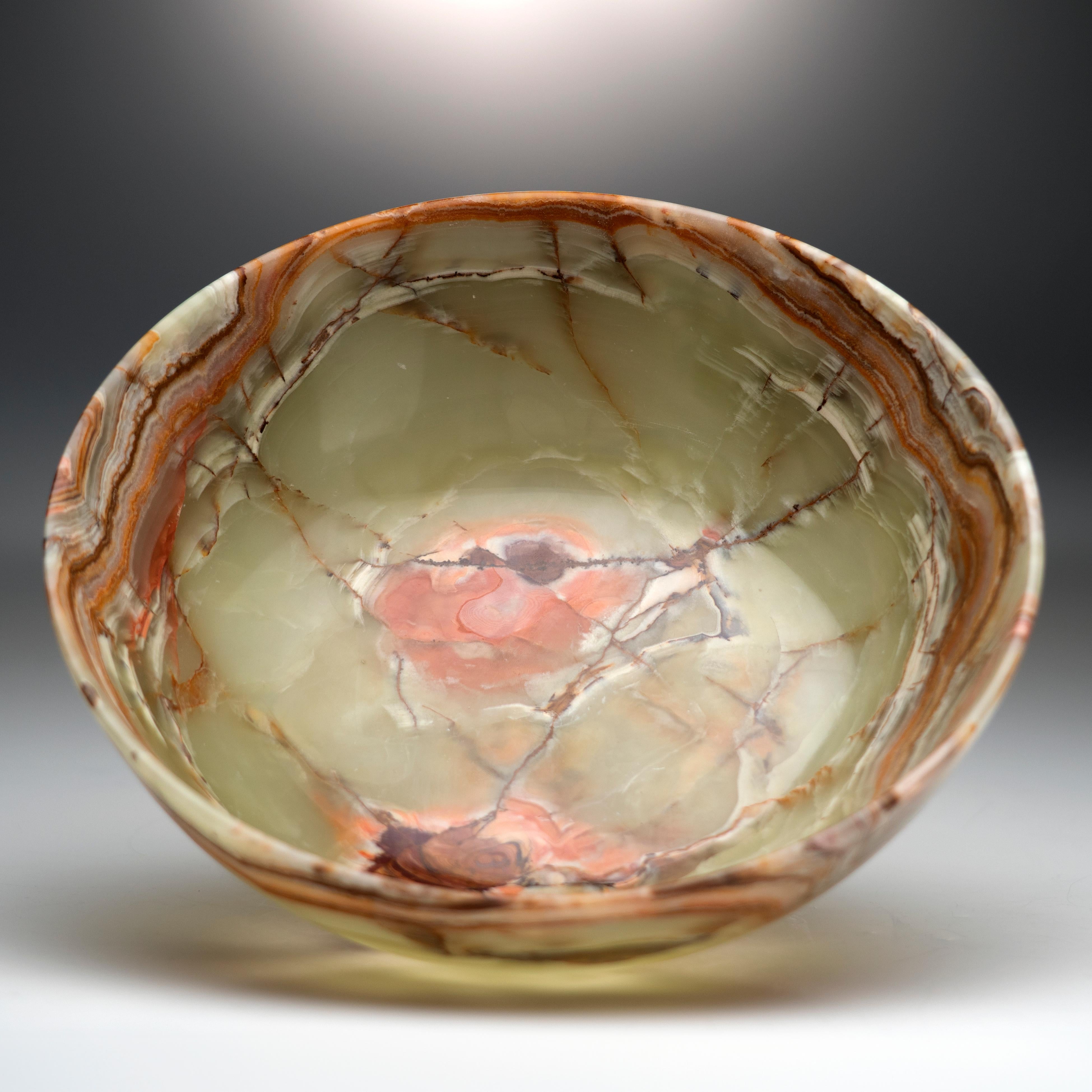 Ce bol en onyx strié représente la fusion de la beauté naturelle et de l'artisanat d'art. Sculptée à la main dans un seul morceau de pierre du Pakistan, formée dans les profondeurs de la terre au cours de millions d'années, elle présente un corps