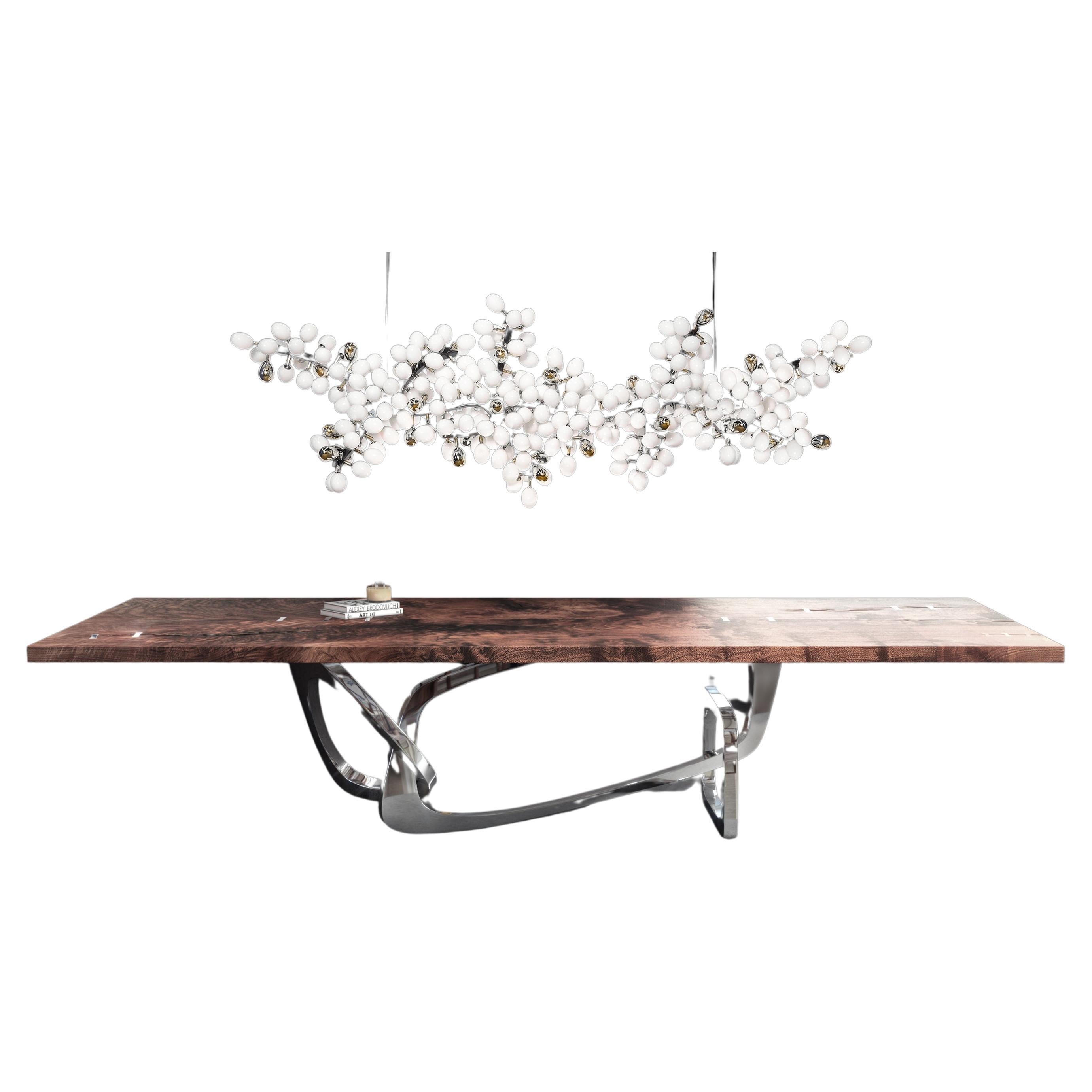 The Bangle dining table by Barlas Baylar is a contemporary interpretation of Art Deco design inspiration by utilizing rigorous craft.  The sculptural Stainless Steel base and Seamed Walnut top  is available in a variety of finishes.  The top can be