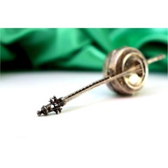 Banjo-shaped silver pill box with reliefs and applications