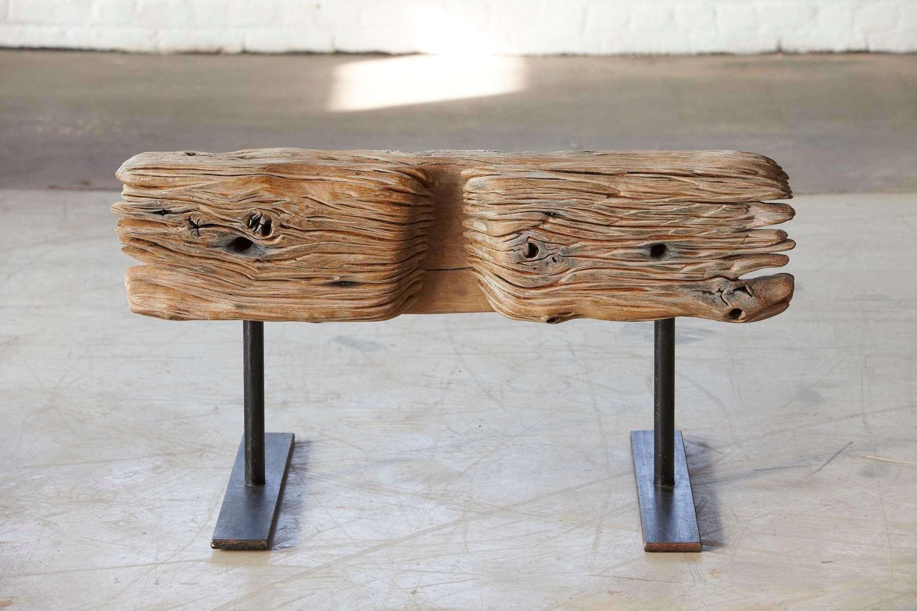 Bank 1 - bench 1
Bench made from a solid piece of oak mounted on a welded black iron legs by German artist Hanni Dietrich. 
All wood used by the artist is from salvaged oak beams or naturally fallen trees.
The integrated iron handles were as