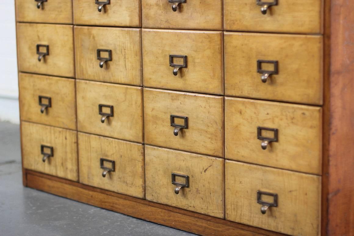 Bank of wooden haberdashery drawers, circa 1930s.

Product code #OA212

- Original brass pull handles with card holders
- Mahogany sides with beech drawer fronts
- Glass top and back
- Original makers badge
- 16 gradiented drawers
-