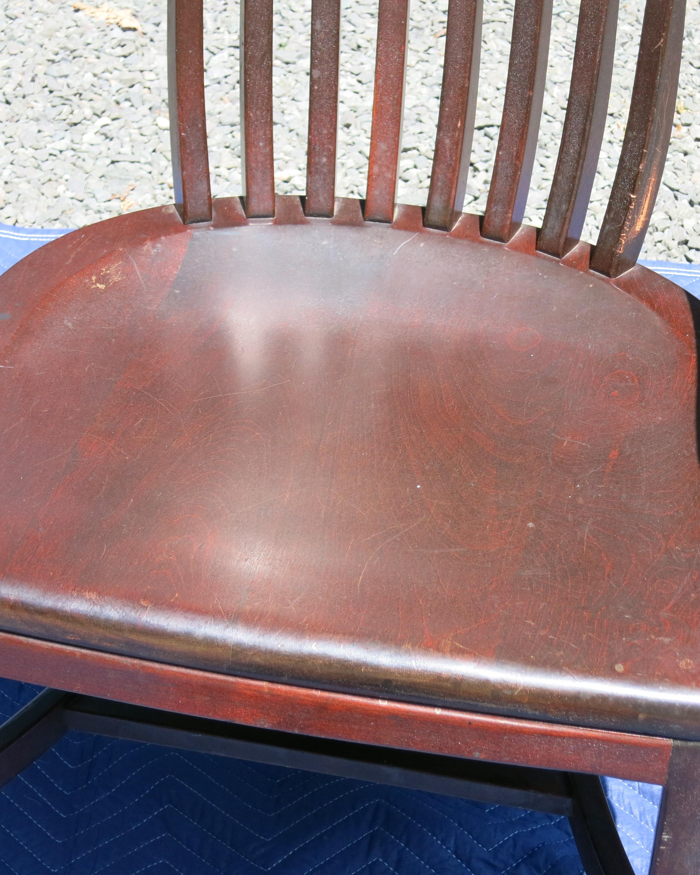 Bankers chair, with red finish possibly mahogany. Wear to finish at armrests. Older chair finish worn. 25