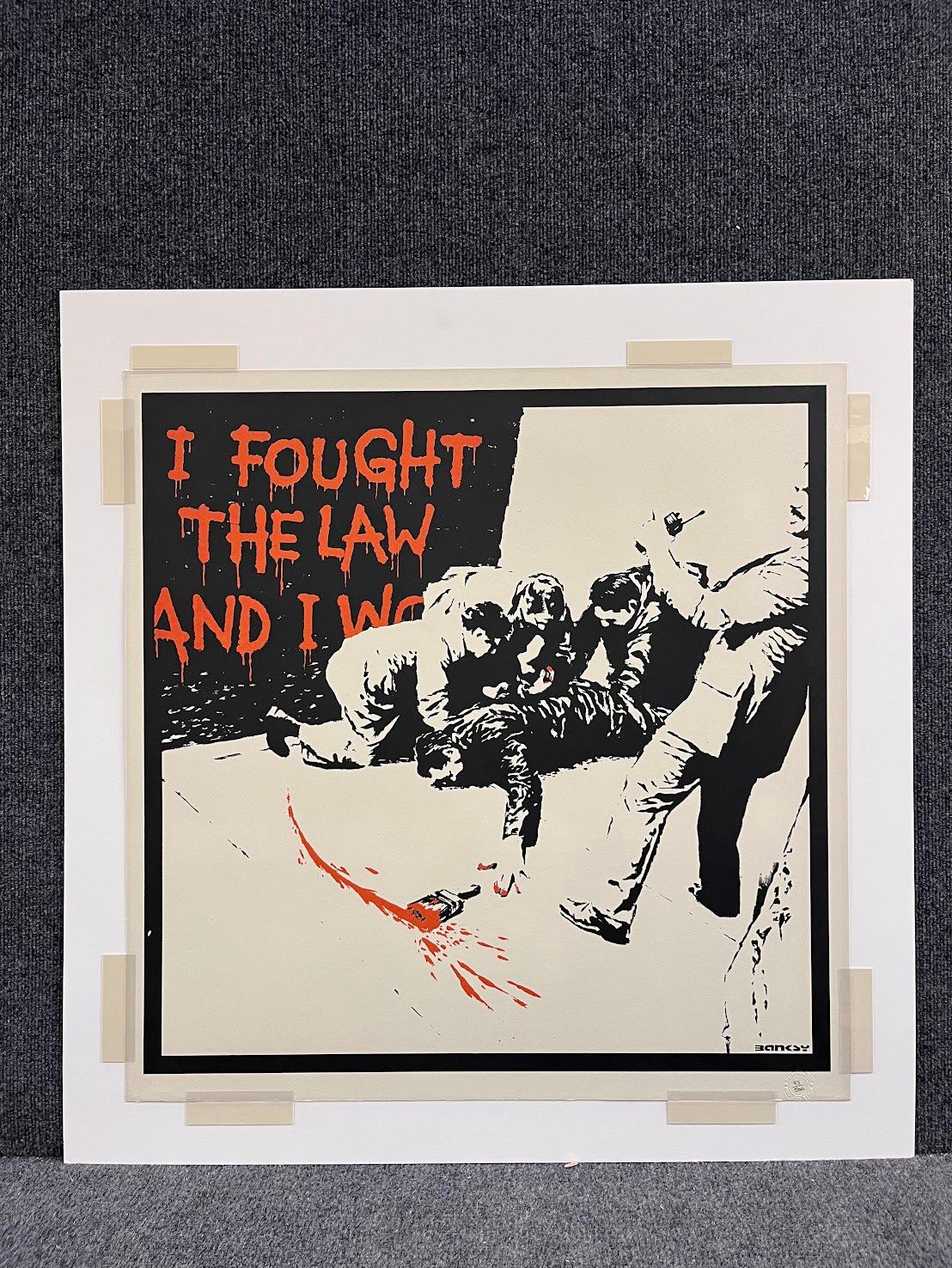 Banksy's 'I Fought the Law' is a 2004 color screenprint, editioned 83/500 in pencil and stamped with the Pictures on Walls, London blindstamp. This magnificent work is in excellent condition measuring 27 3/4 x 27 1/2 in. 

This piece is in excellent