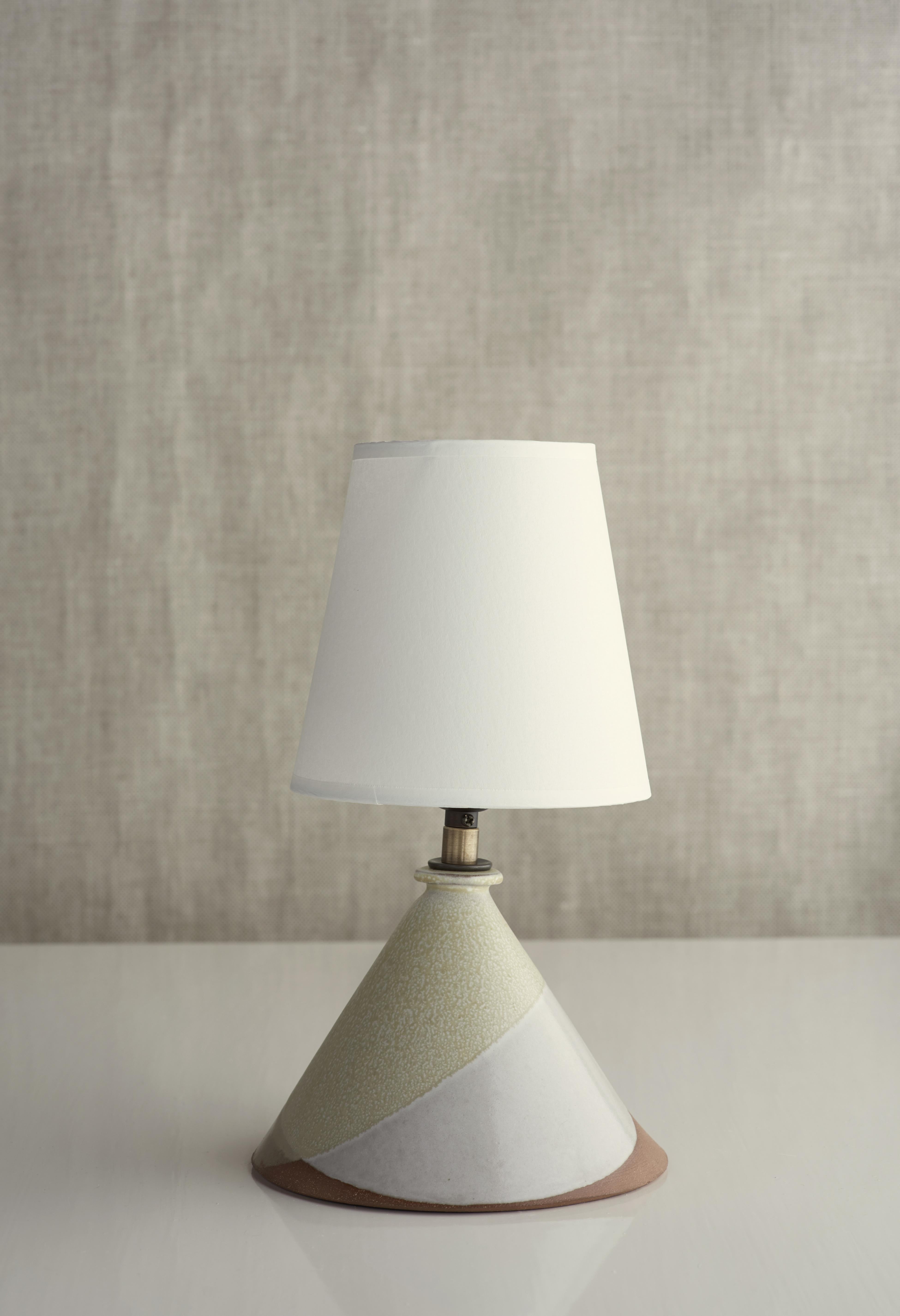 Description

Handmade stoneware slab construction. Lamps are individually crafted and one of a kind.

Finish

Gloss white & cream glaze. Antique brass fittings with braided black cloth cord and off-white paper shade.

Dimensions

Lamp