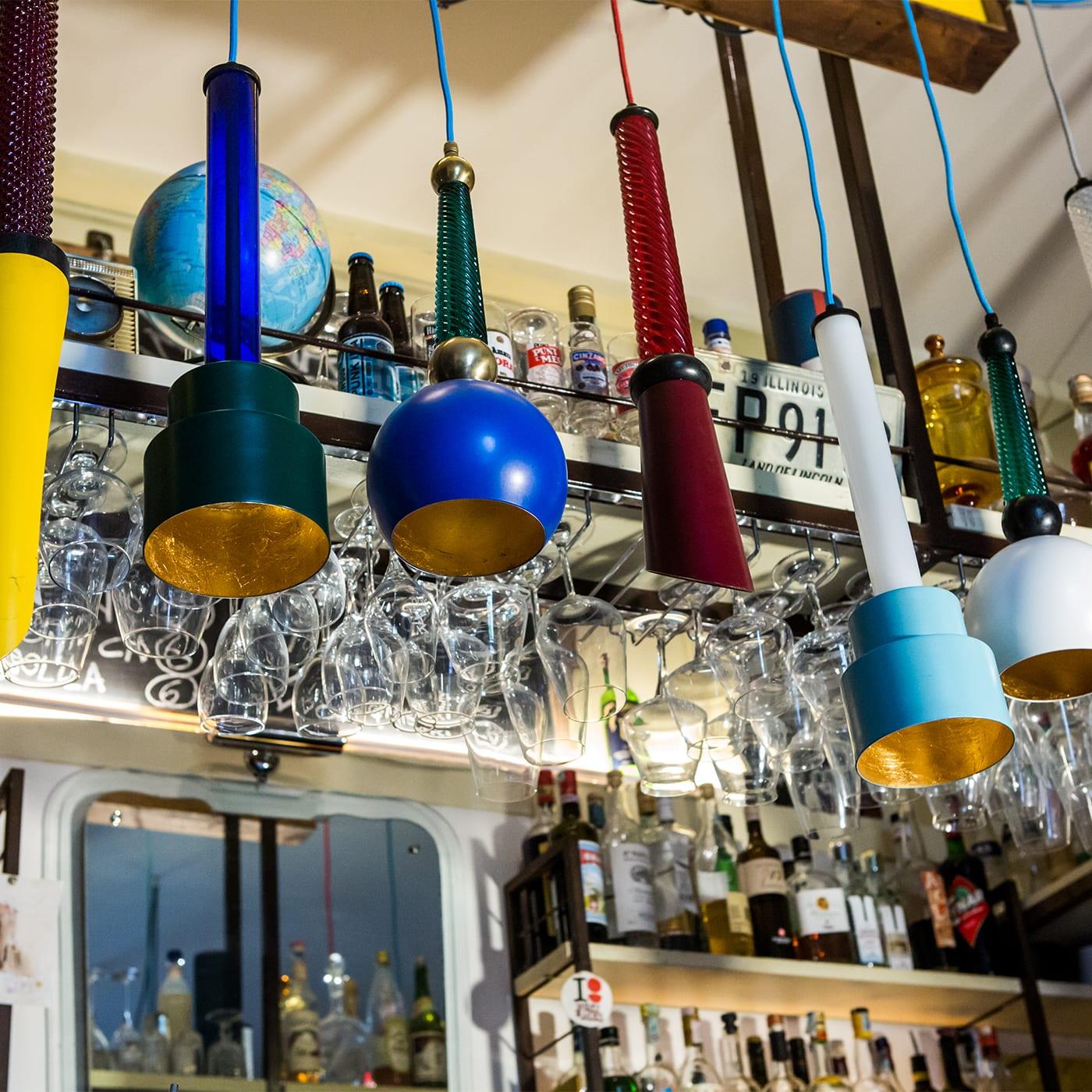 A forma di torcia, questa lampada da soffitto elegante e moderna sarà un'aggiunta accattivante e colorata in un interno contemporaneo. La struttura in ottone ha una finitura nera ed è ornata da un inserto cilindrico in vetro blu, il cui aspetto