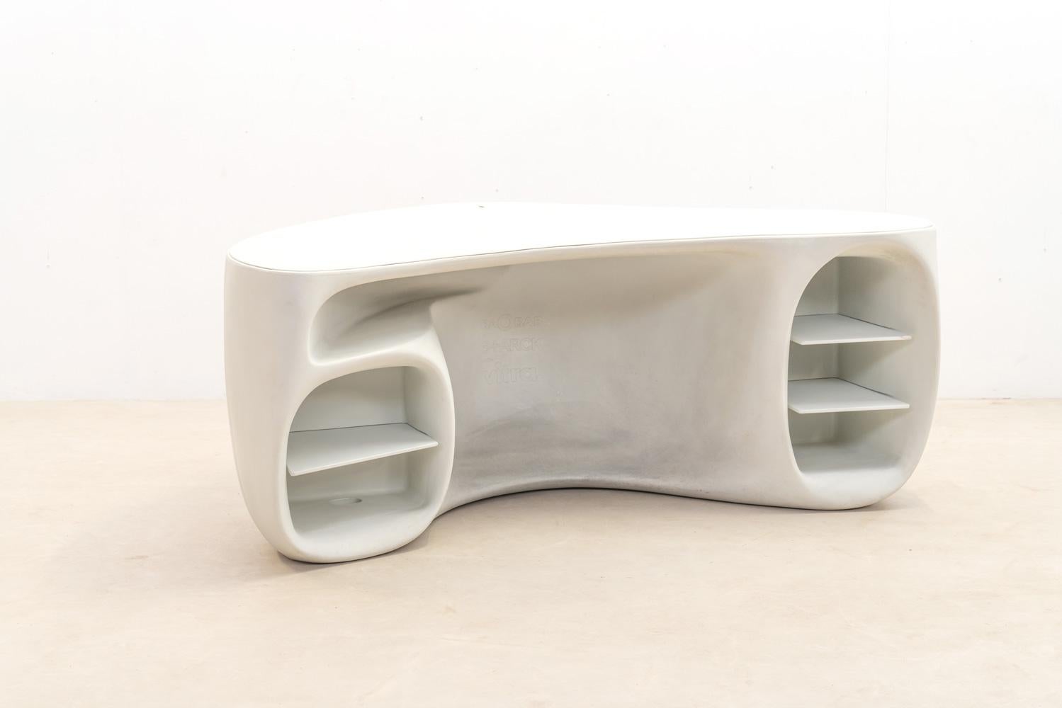 Der Baobab-Schreibtisch, eine Kreation von Philippe Starck für Vitra, stellt mit seiner nahtlosen Integration von Funktionalität und Ästhetik traditionelle Büromöbel in Frage. Der aus einem Stück gefertigte Schrank bietet Stauraum und