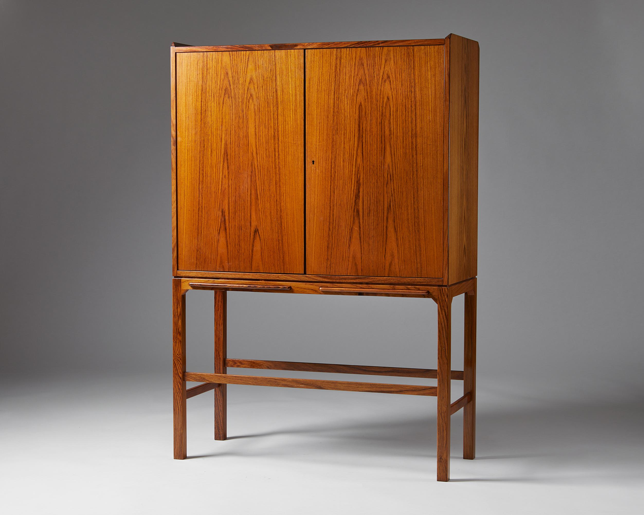 Bar cabinet, anonymous,
Sweden. 1960s.
Rosewood and mirror glass.

This elegant anonymous bar cabinet is an exquisite example of Scandinavian cabinetmaking. The pattern created by the book matched rosewood veneer on the cabinet’s top, front, and