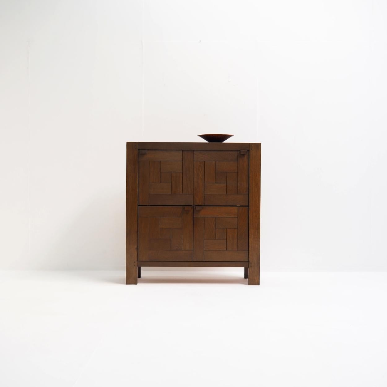 Meuble de bar belge brutaliste conçu dans les années 1970 par Frans Defour pour Defour.

L'armoire est composée d'un cadre en chêne massif et de panneaux de porte en placage de chêne qui présentent un design graphique. Chaque compartiment de