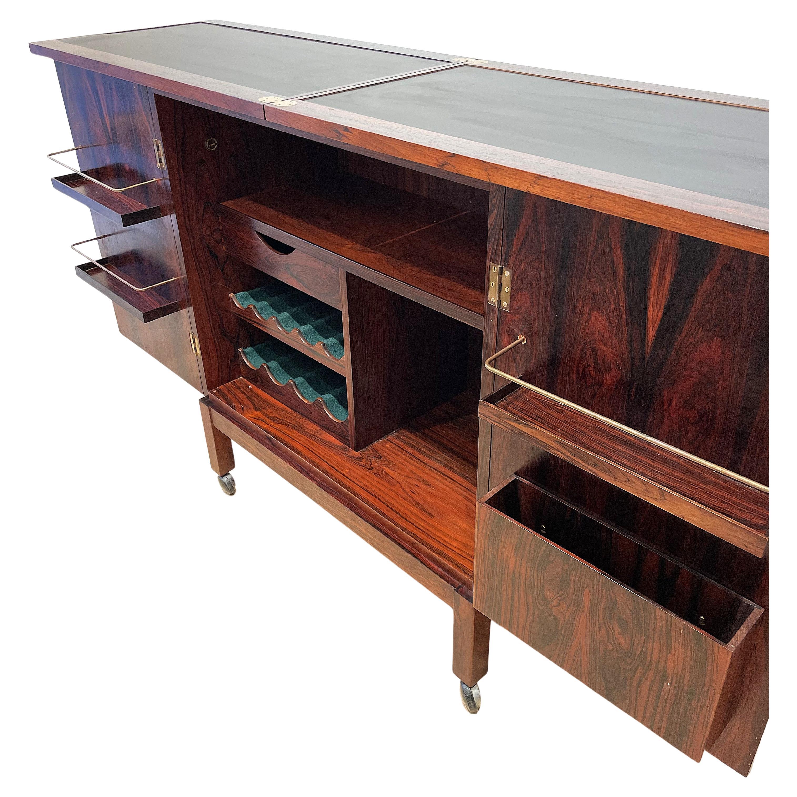 Bellissimo e ingegnoso mobile bar disegnato da Torbjorn Afdal e prodotto da Bruksbo, Norvegia, negli anni '60. La struttura è realizzata in palissandro Rio, in un colore intenso, e i piani del bar sono in formica nera. Molto decorativo, questo bar