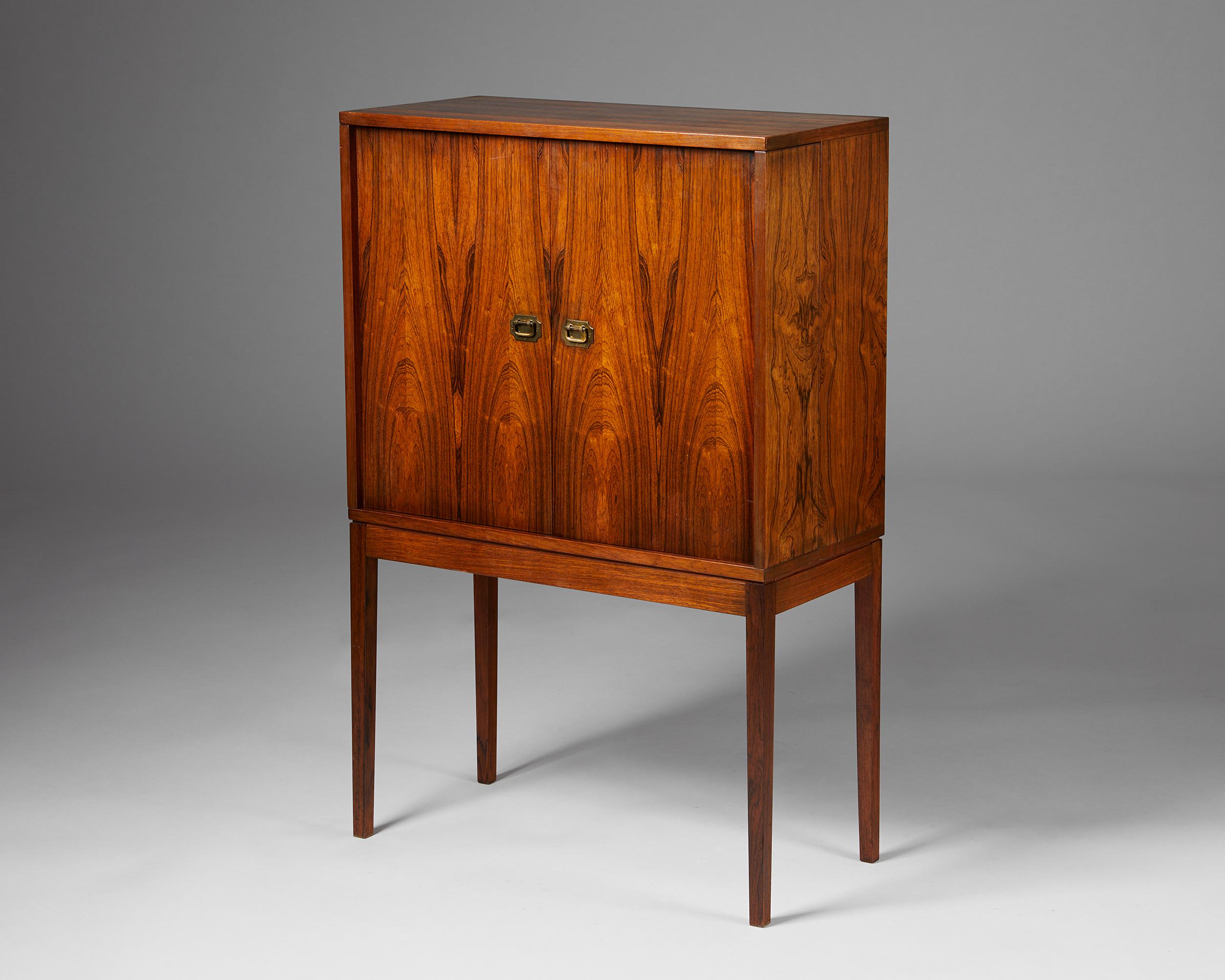 Bar cabinet designed by Henning Korch for CF Christensen Silkeborg,
Denmark, 1960s.
Rosewood and brass.

Henning Korch’s design aesthetic is characterised by the effective use of rosewood veneer and small colonial style brass handles. This compact