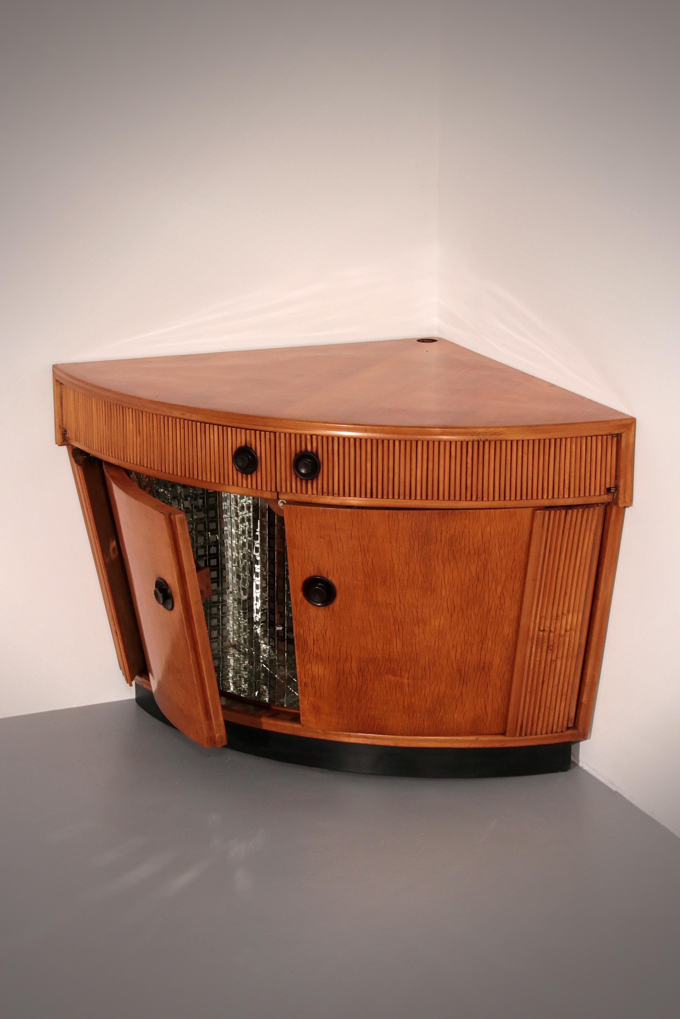 This rare Grissinato Bar Cabinet in light wood, attributed to Paolo Buffa and dating from the 1940s, is an exquisite example of Italian Art Deco elegance. The exterior displays refined craftsmanship and a timeless silhouette, while the interior