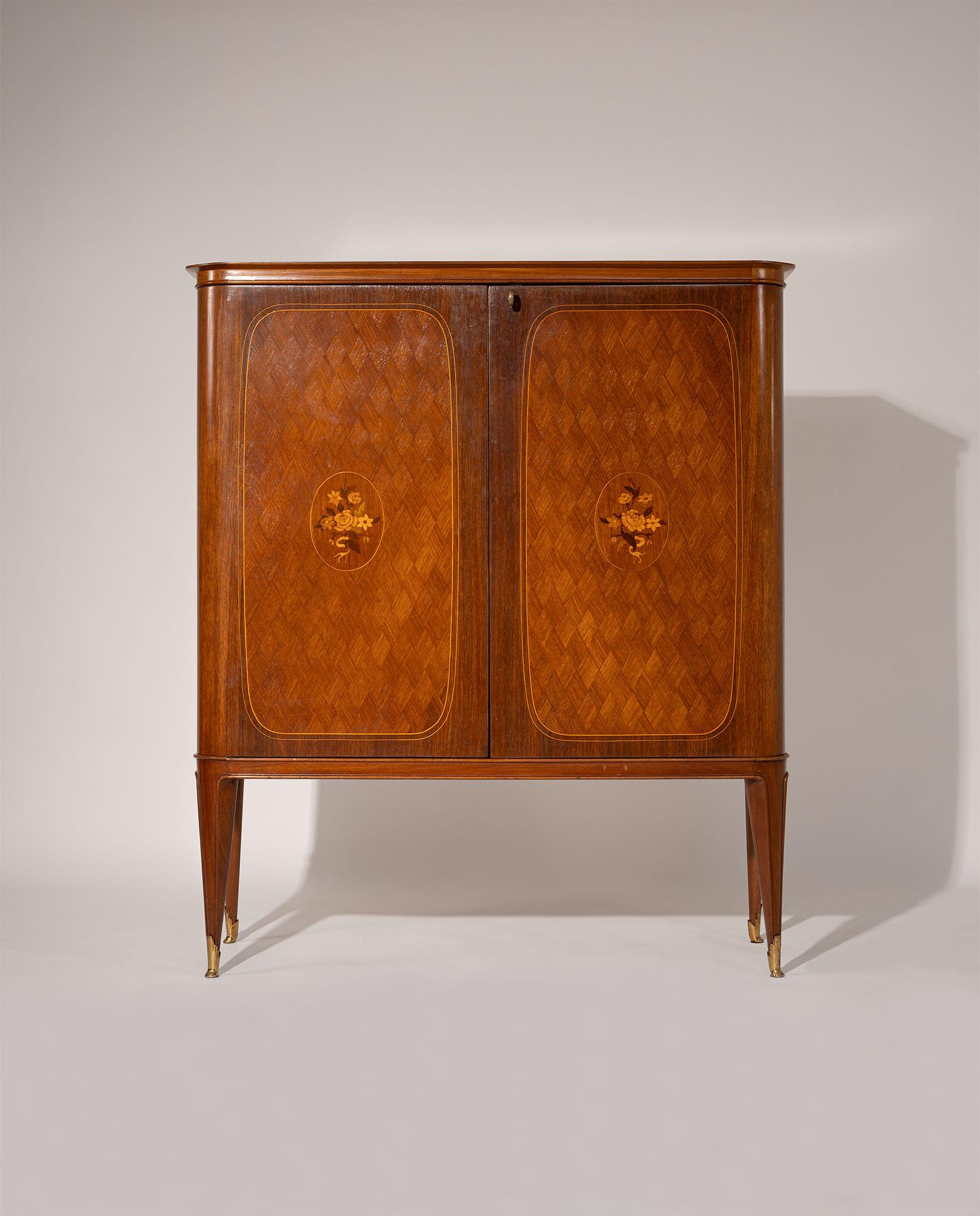 Bar cabinet, Italy, 1950s. Designed in the refined style of Paolo Buffa, this exquisite piece exemplifies the Italian mid-century neoclassical aesthetic. Meticulously crafted with exceptional attention to detail, the cabinet features a sophisticated