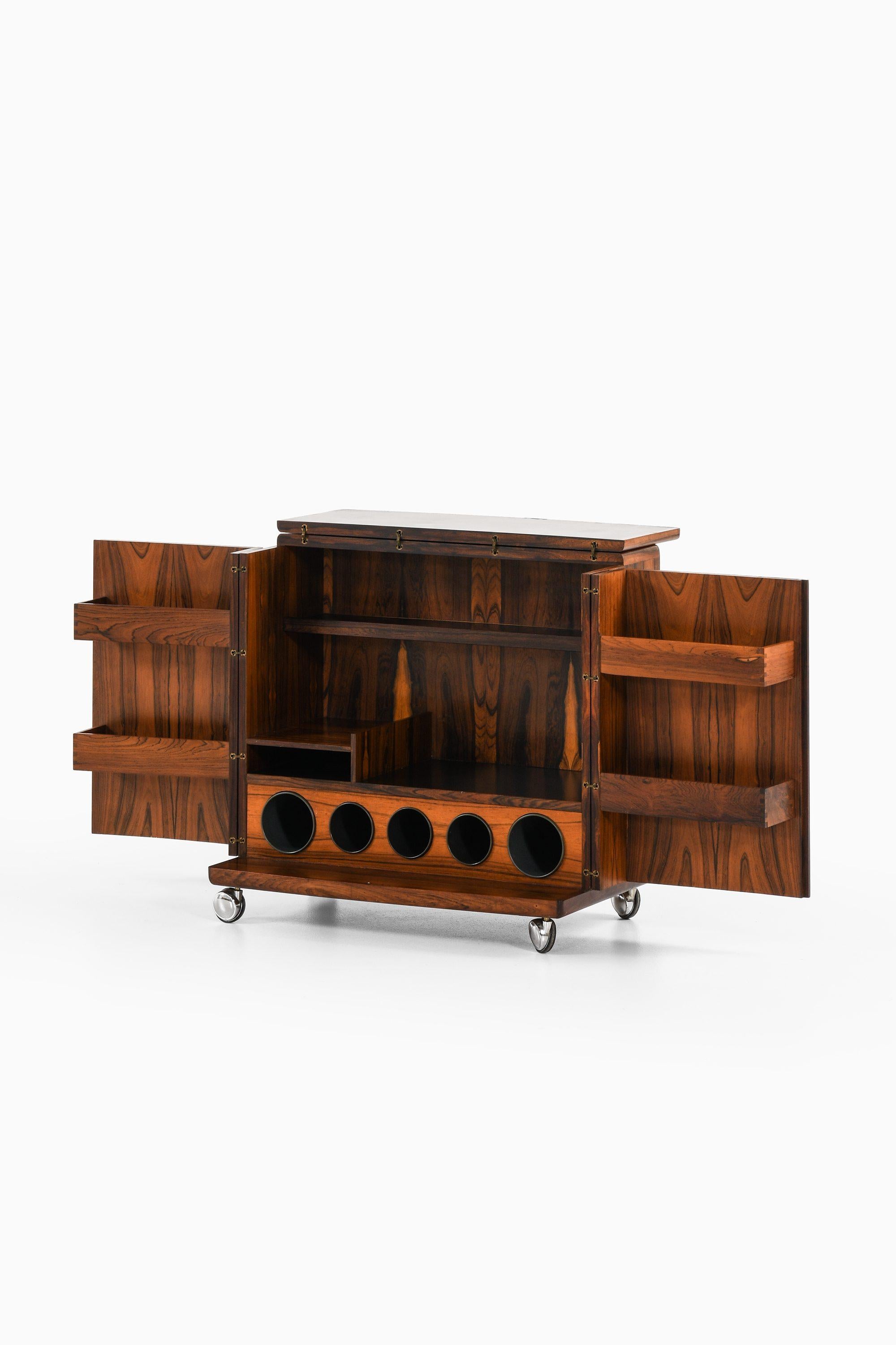 Mobile bar su ruote in palissandro, ottone, formica e acciaio di Illum Wikkelsø, anni '60

Informazioni aggiuntive:
Materiale: Palissandro, ottone, formica e acciaio
Stile: Metà secolo, Scandinavia
Prodotto in CFC Silkeborg
Dimensioni (L. x P. x