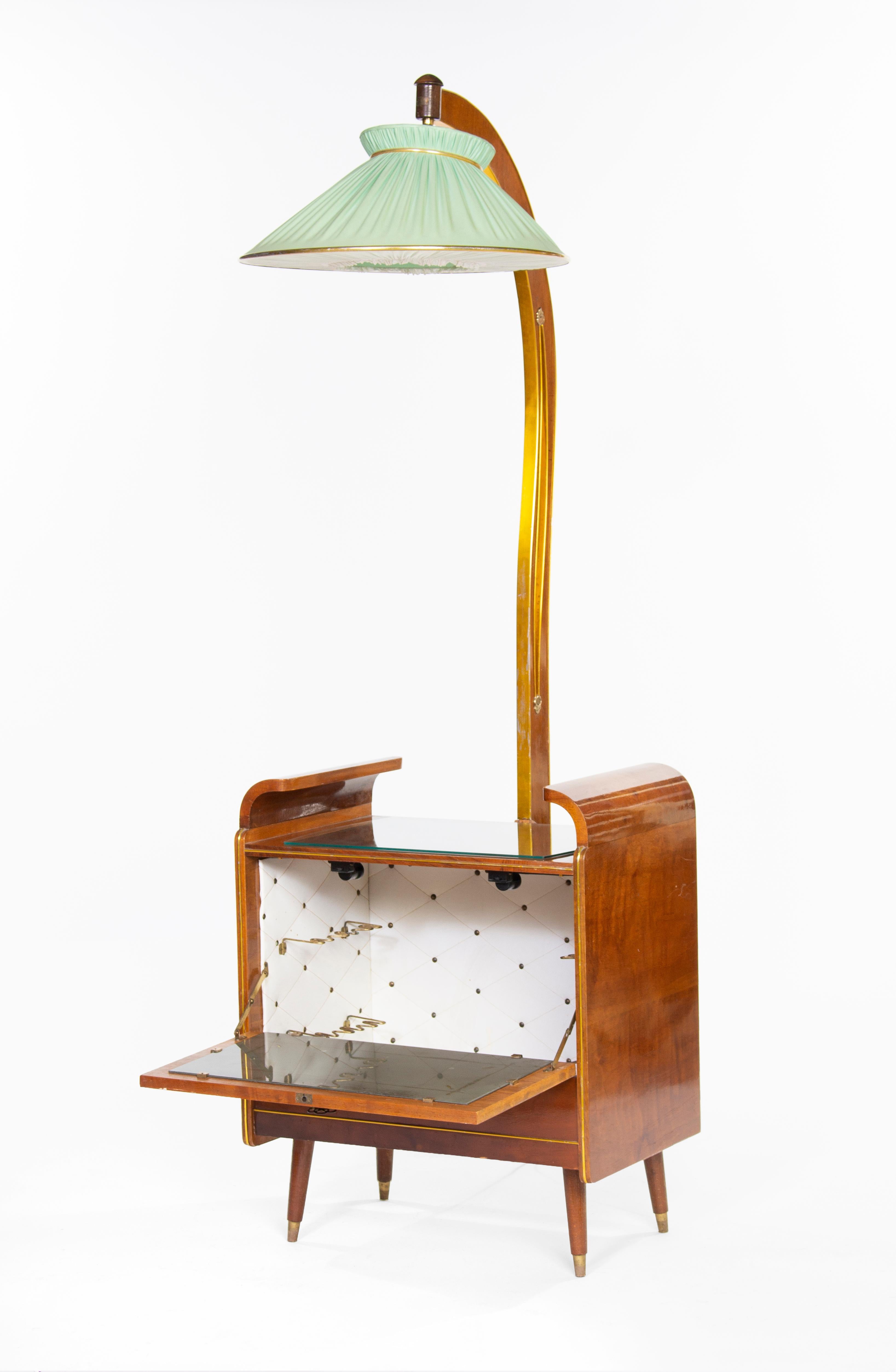 Retro style Mid-Century Modern bar cabinet, manufactured around 1960s.
The pine structure is given a warm walnut veneer.
The stylish cabinet features inside storage capacity, a glass surface and a delicate menthe coloured lampshade, with a