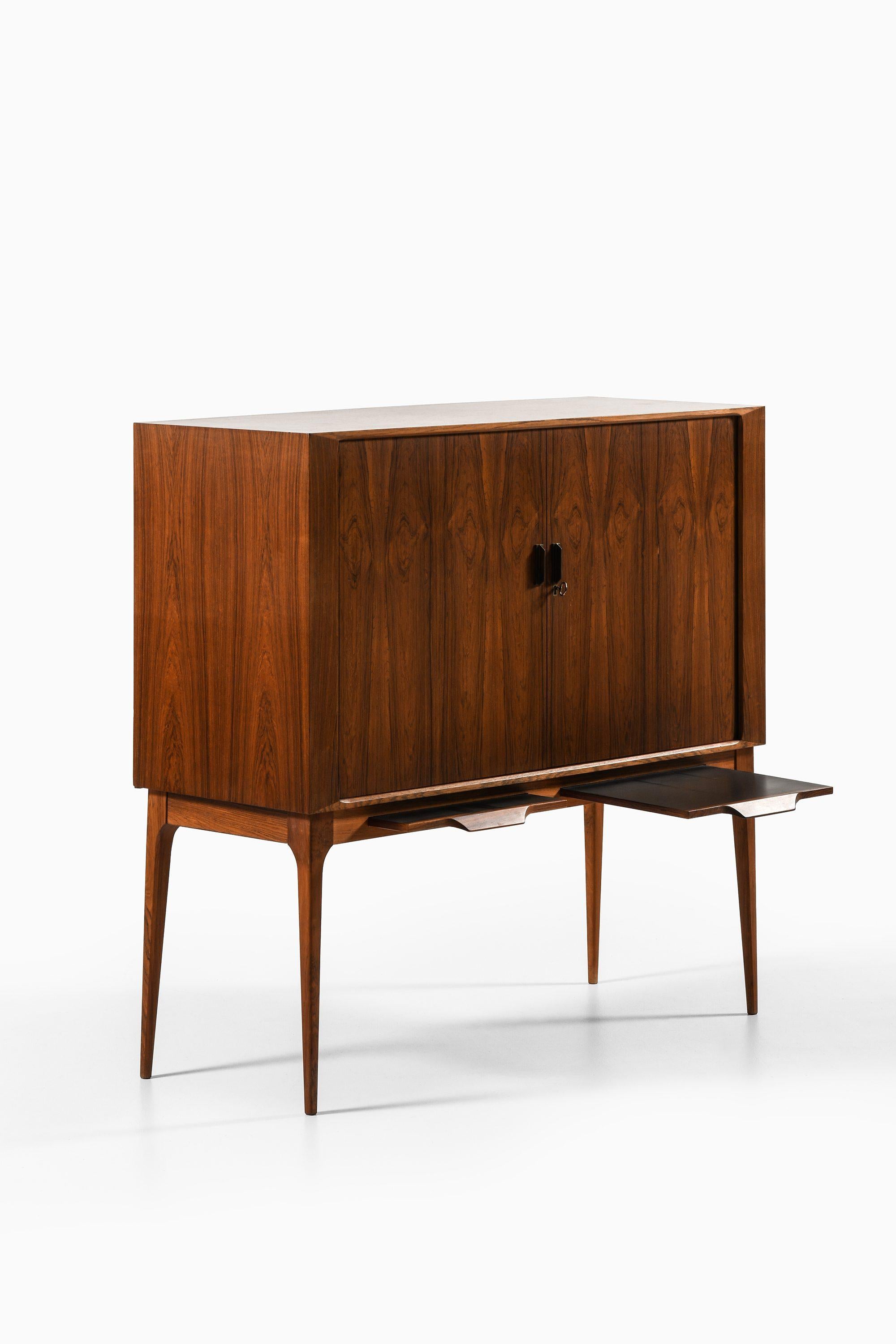 Bar Cabinet with Tambour Doors in Rosewood, Brass and Glass by Kurt Østervig, 1960's

Additional Information:
Material: Rosewood, brass and glass
Style: Mid century, Scandinavian
Produced by K.P Møbler in Denmark
Dimensions (W x D x H): 120 x 45.5 x