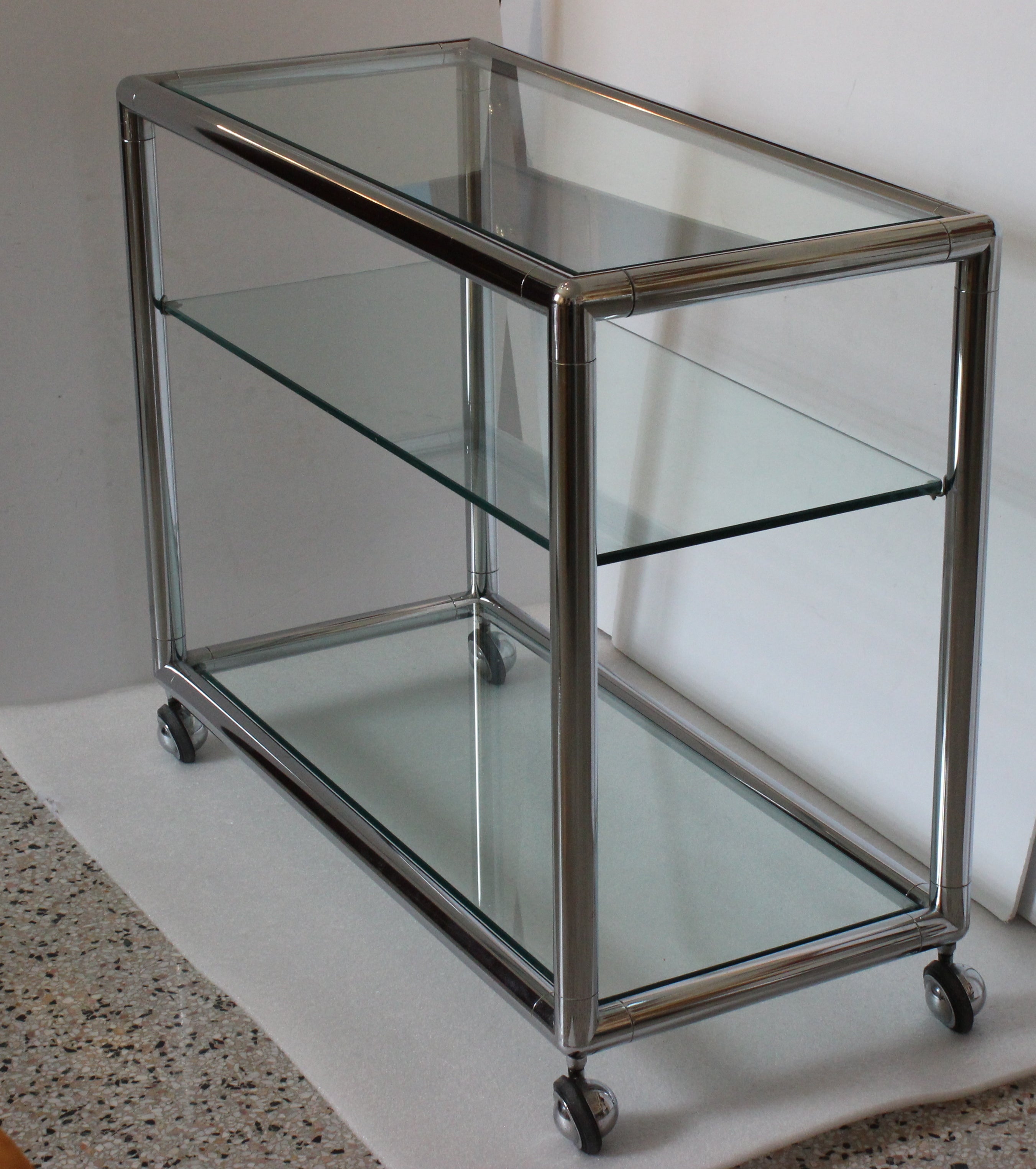This chic and cleanlined bar cart dates to the late 1970s to the early 1980s and is attributed to Pace Furniture. The piece is fabricated in polished chrome and tempered glass shelves.

The cart glides with ease and will make for the perfect piece