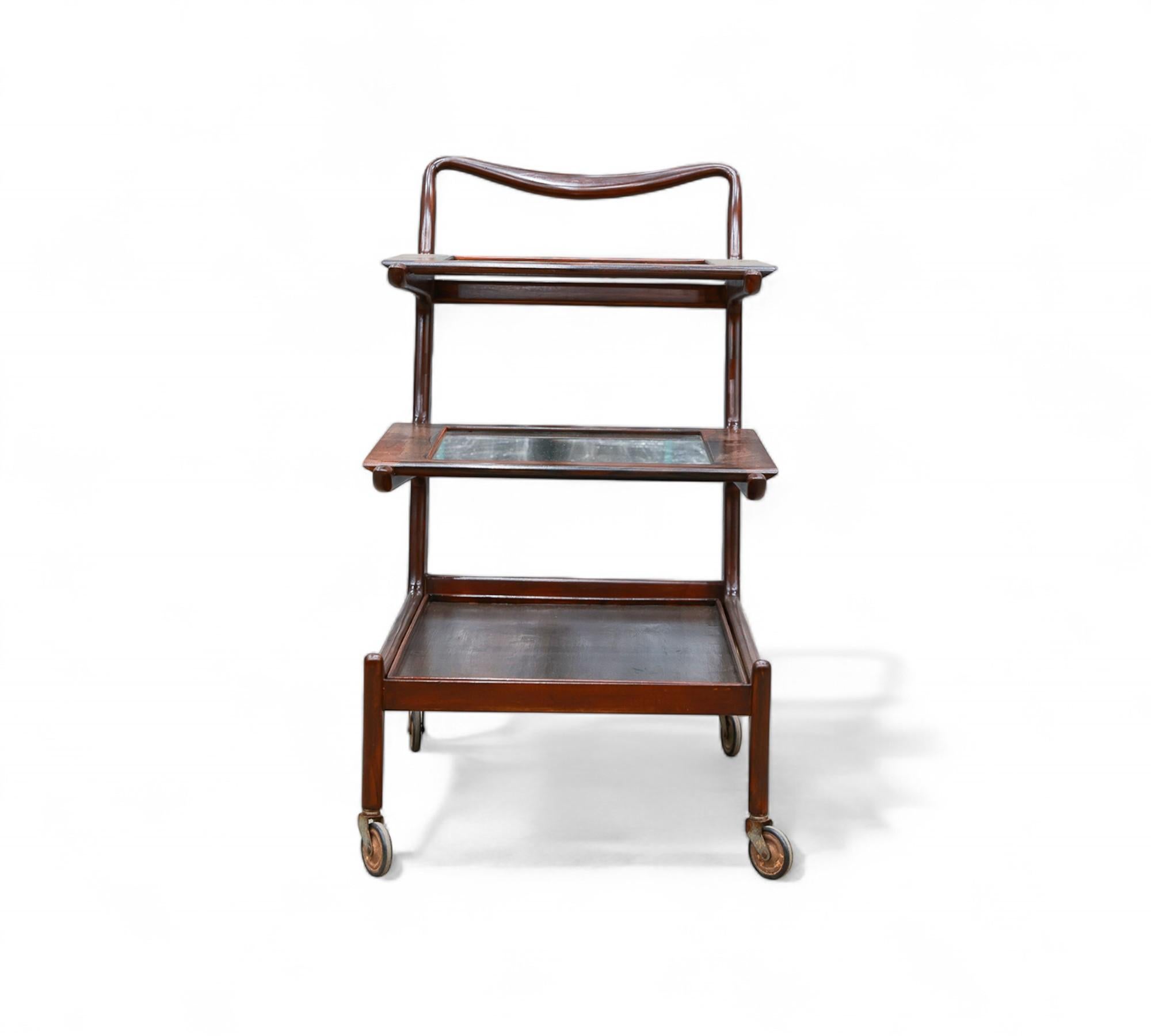 Carlo Hauner y Martin Eisler diseñaron este impresionante carrito de bar para Forma S/A Móveis e Objetos de Arte en la década de 1950. Fabricada en palisandro de Brasil (Jacaranda), cristal y acero, cuenta con tres bandejas de servicio extraíbles