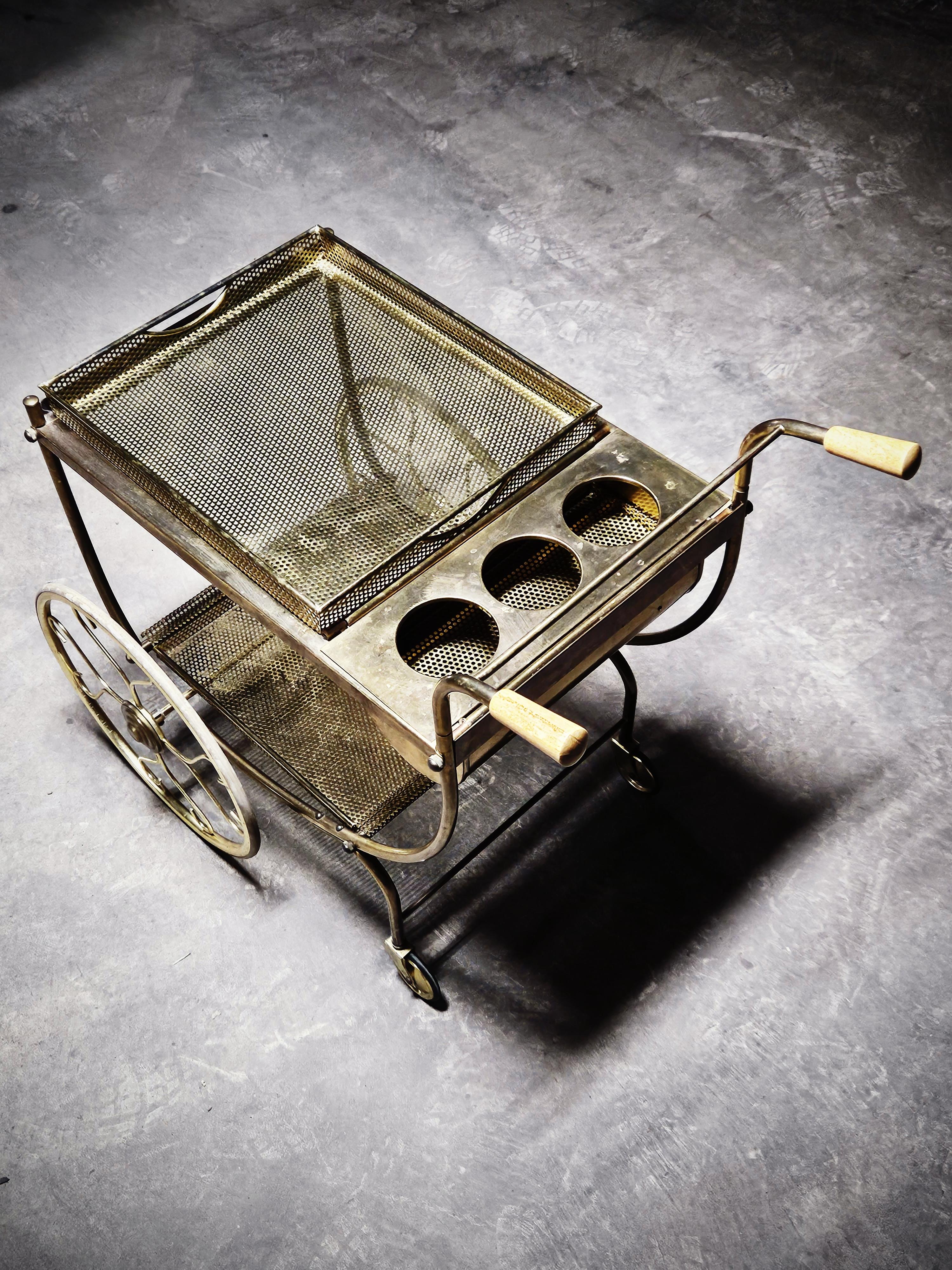 Chariot de bar classique produit par Svenskt tenn et conçu par Josef Frank dans les années 1950. Fabriqué en laiton, verre et poignées en bois. Plateau amovible avec poignées. 

Ce modèle est rare et comporte trois porte-bouteilles. 