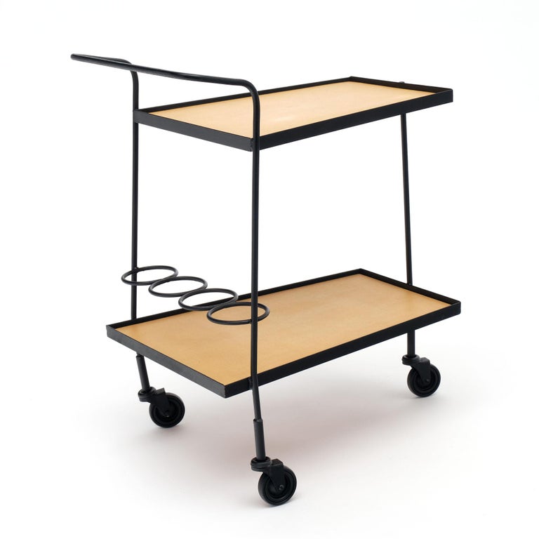 French Bar cart by Iconic designer Mathieu Mategot. This piece has a black lacquered steel structure with two Moleskin “ (to verify). The Modernist piece features a bottle holder and casters.