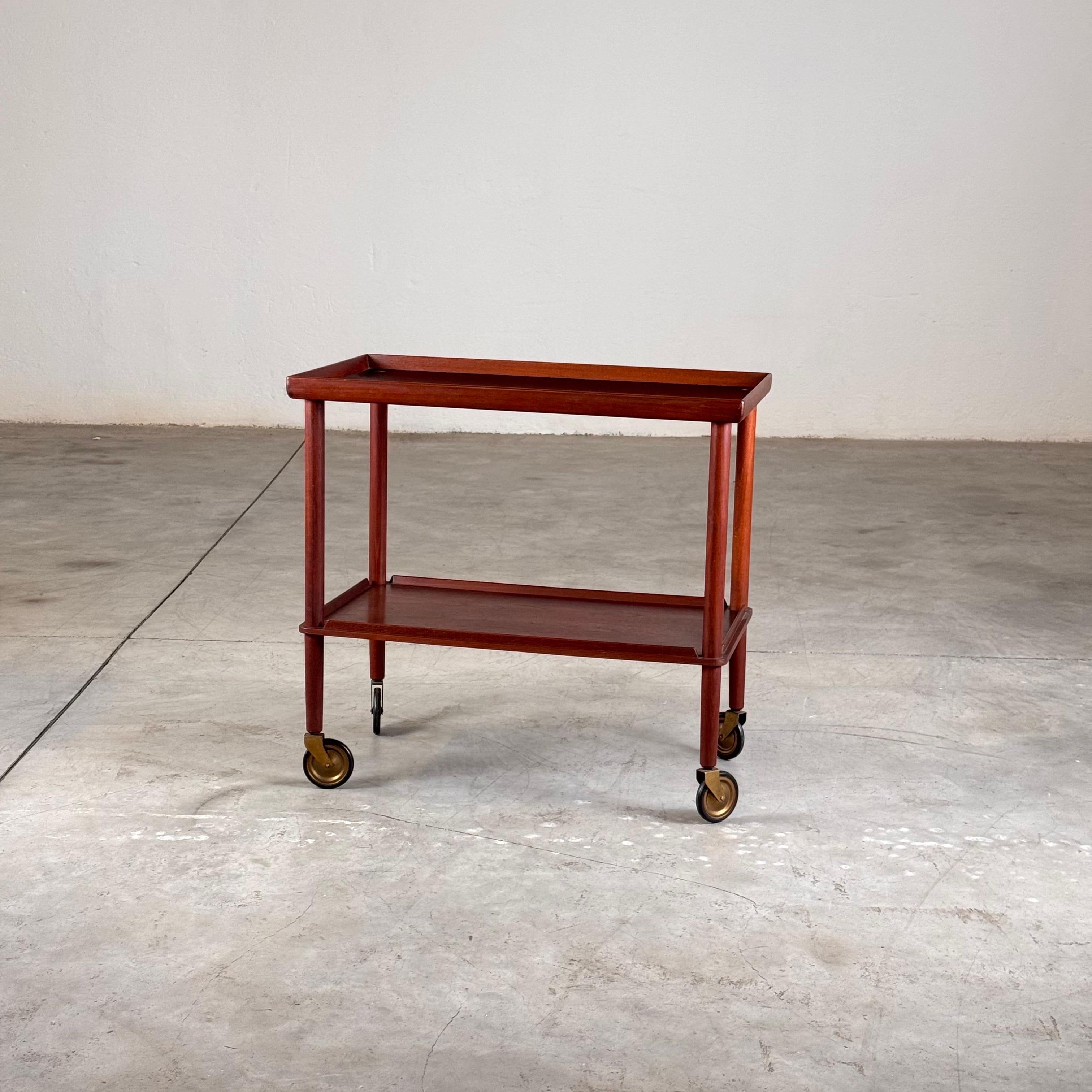 Rare bar cart designed by Peter Hvidt & Orla Mølgaard-Nielsen for Søborg Møbler in the 1960s, an exquisite example of Danish modern design and craftsmanship. The piece features a solid teak structure with elegantly tapered legs resting on refined