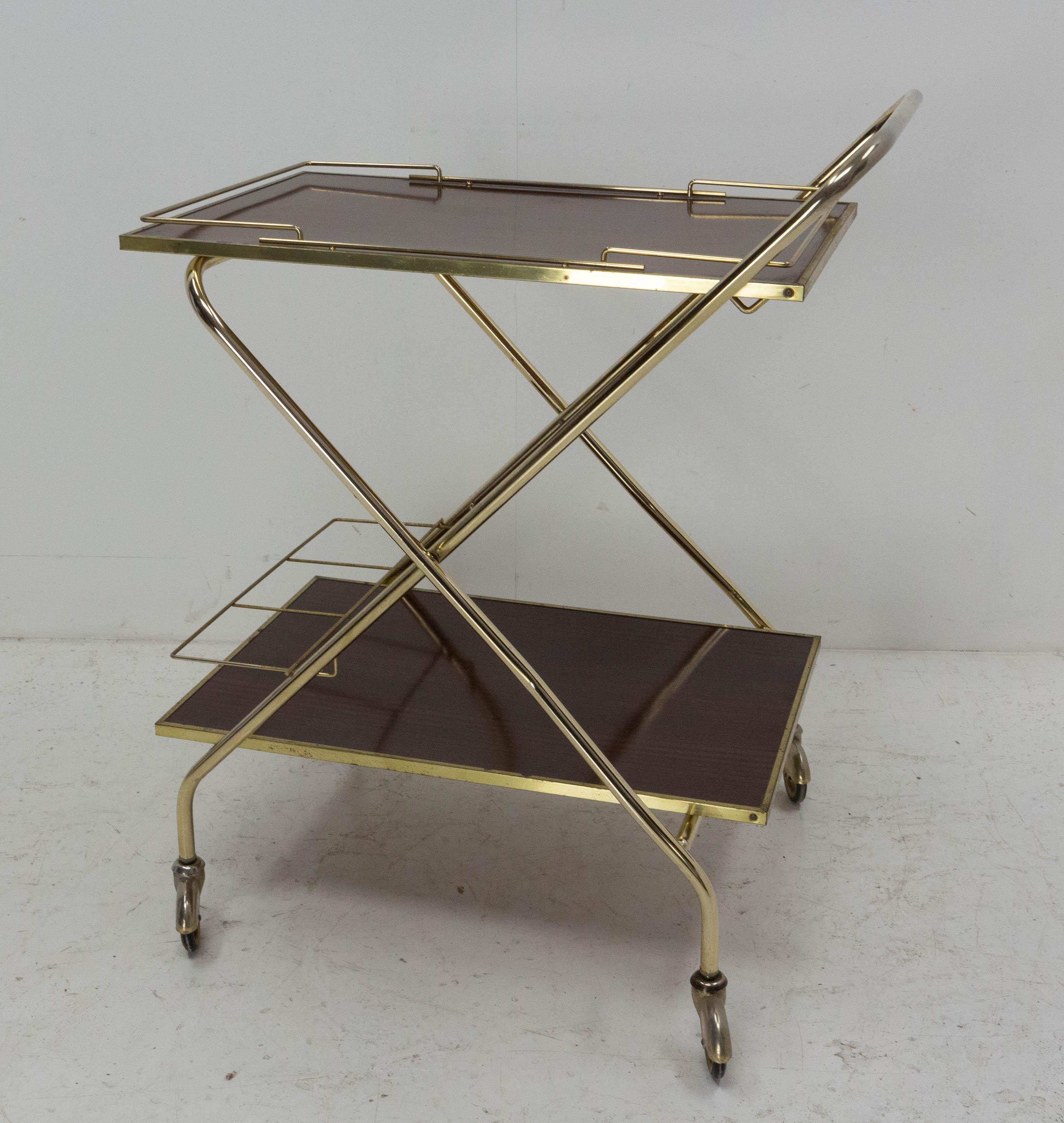 Vintage bar cart drinks or cocktail trolley, 
French, circa 1960, wood recovered of polyester and brass.
Dimension when the cart is folded : W 40.94 in. (104 cm), D 28.87 in. (53 cm), H 5.51 in. (14 cm)
Good vintage condition.


Shipping:
L104 P53