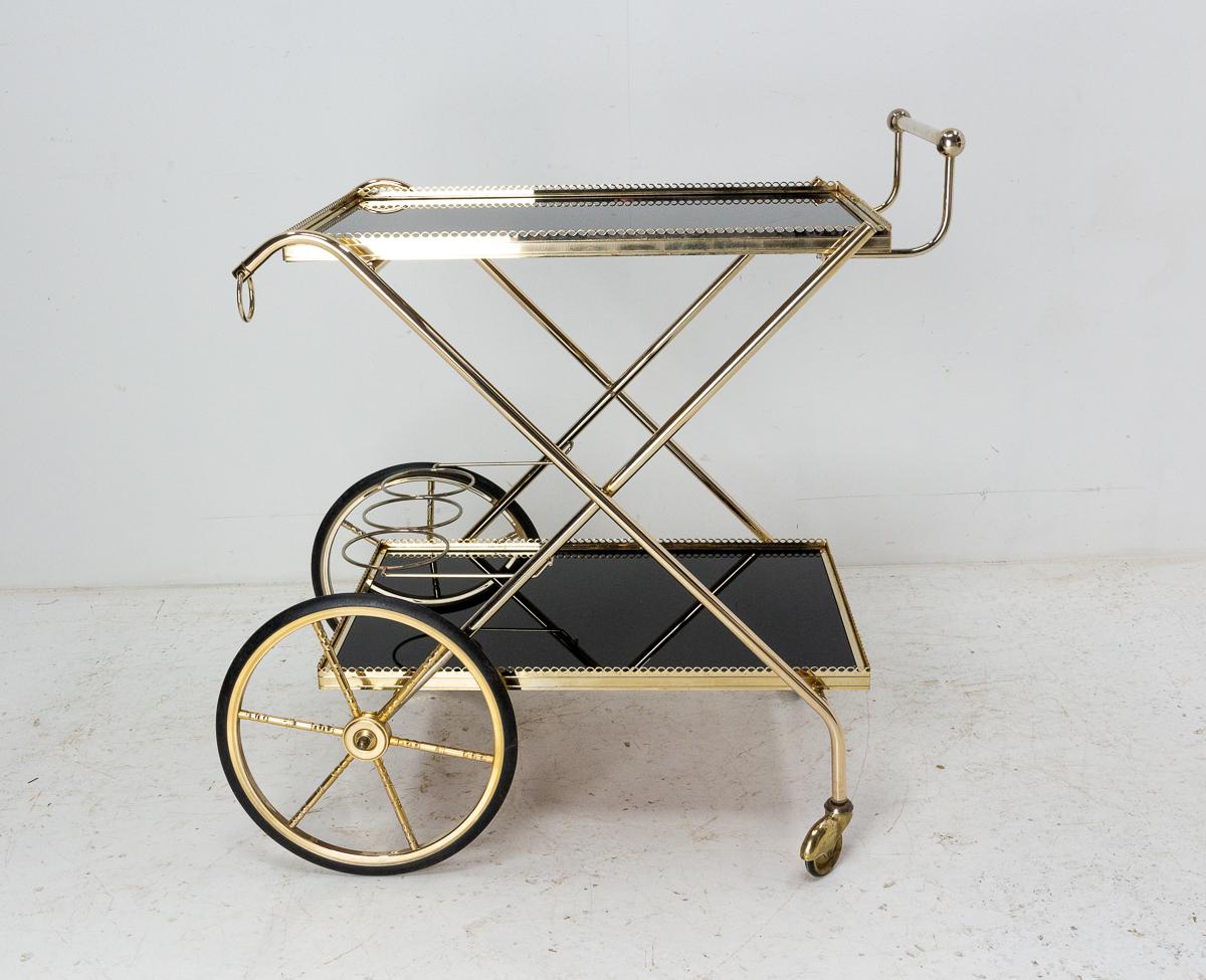 Vintage bar cart drinks or cocktail folding trolley, 
French, 1977, wood recovered of glass and brass.

Good vintage condition, the wood painting is blistered, nothing disturbing


Shipping:
L98 P49 H22 11,5 Kg.