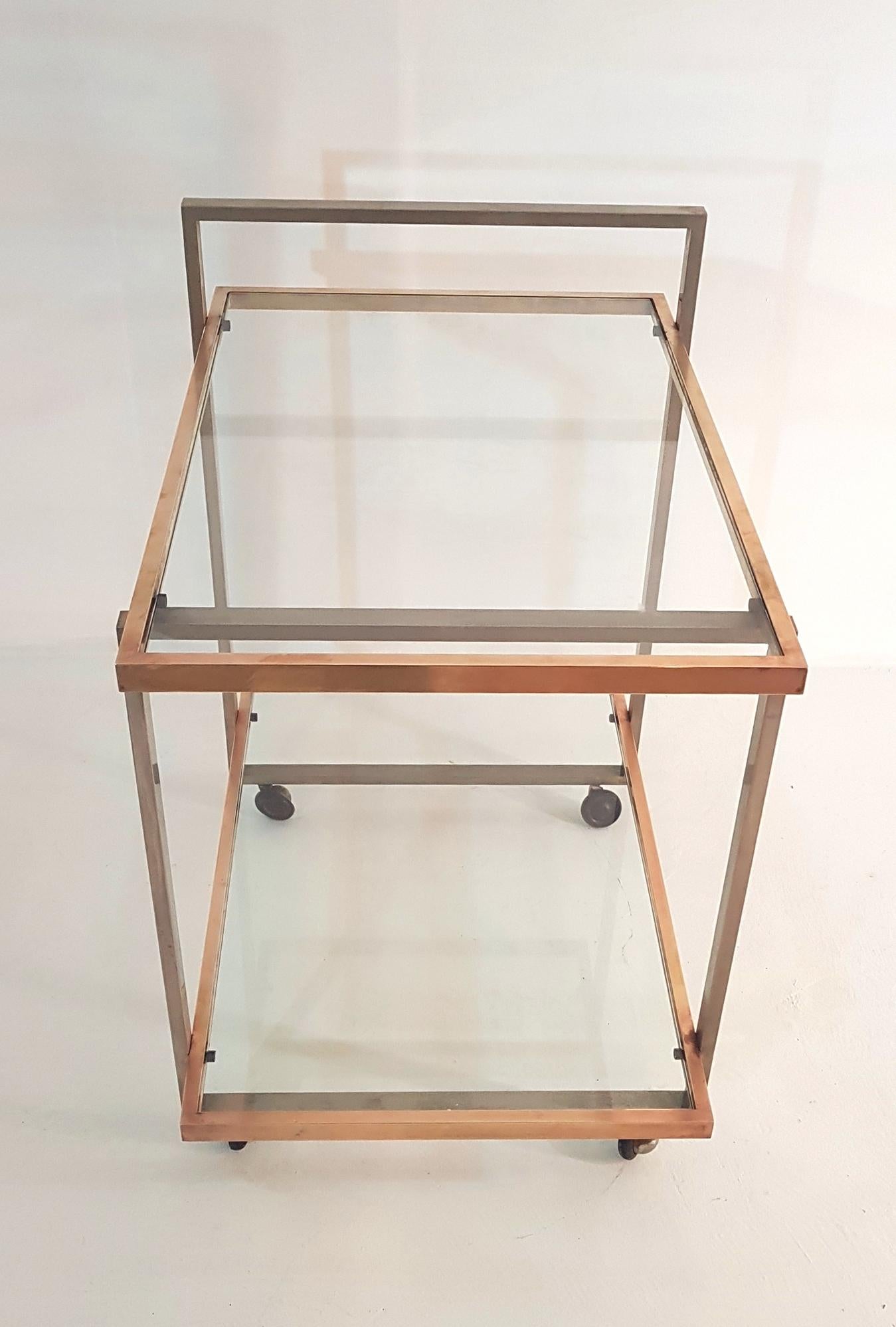 Elegant two-tiered bar cart with clear glass shelves. The wheels are original and work well.