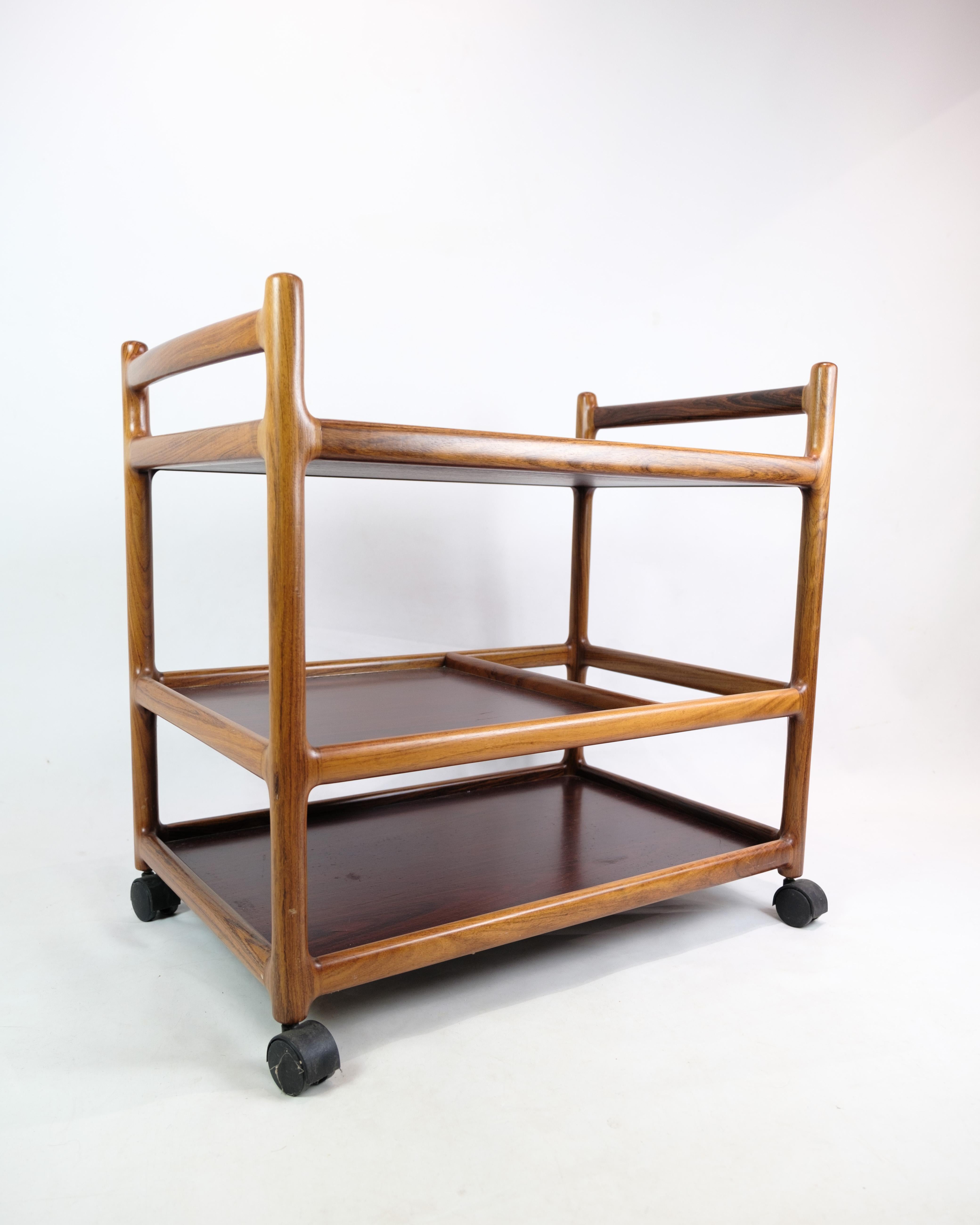 Der von Johannes Andersen entworfene und von der Silkeborg Møbelfabrik in den 1960er Jahren hergestellte Rolltisch aus Palisanderholz ist ein Beispiel dänischer Möbelkunst aus der Mitte des 20. Jahrhunderts. Johannes Andersen war für sein elegantes