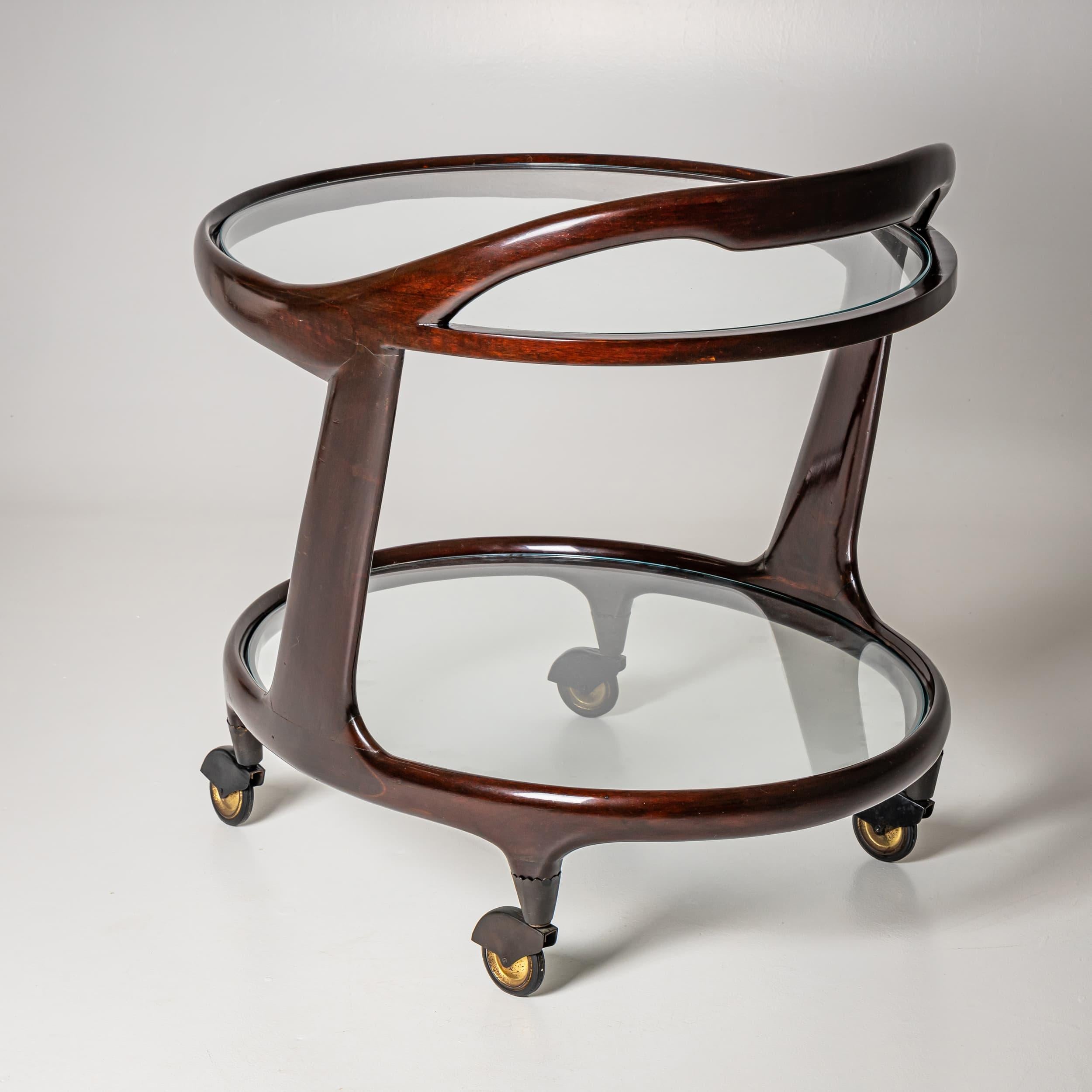 Carrello da bar di Cesare Lacca con ripiani ovali in vetro a due livelli e rotelle in ottone. Il telaio in legno con finitura liscia include una maniglia per spingere il carrello. In condizioni originali non restaurate.