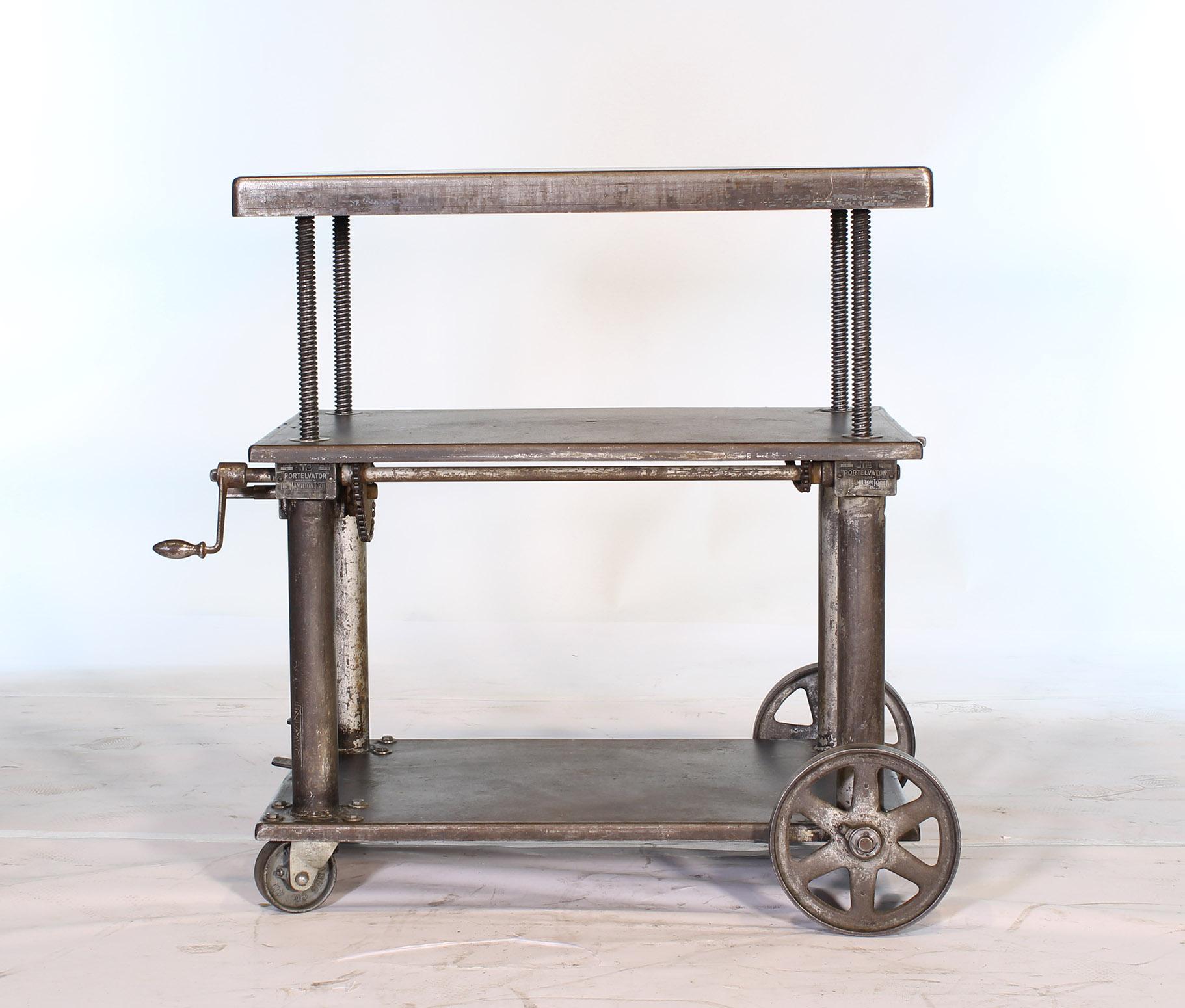 Original vintage Industrial adjustable metal, steel rolling three tier lift bar cart / table with cast iron casters / wheels. Measure: Top is adjustable in height from 25 1/4
