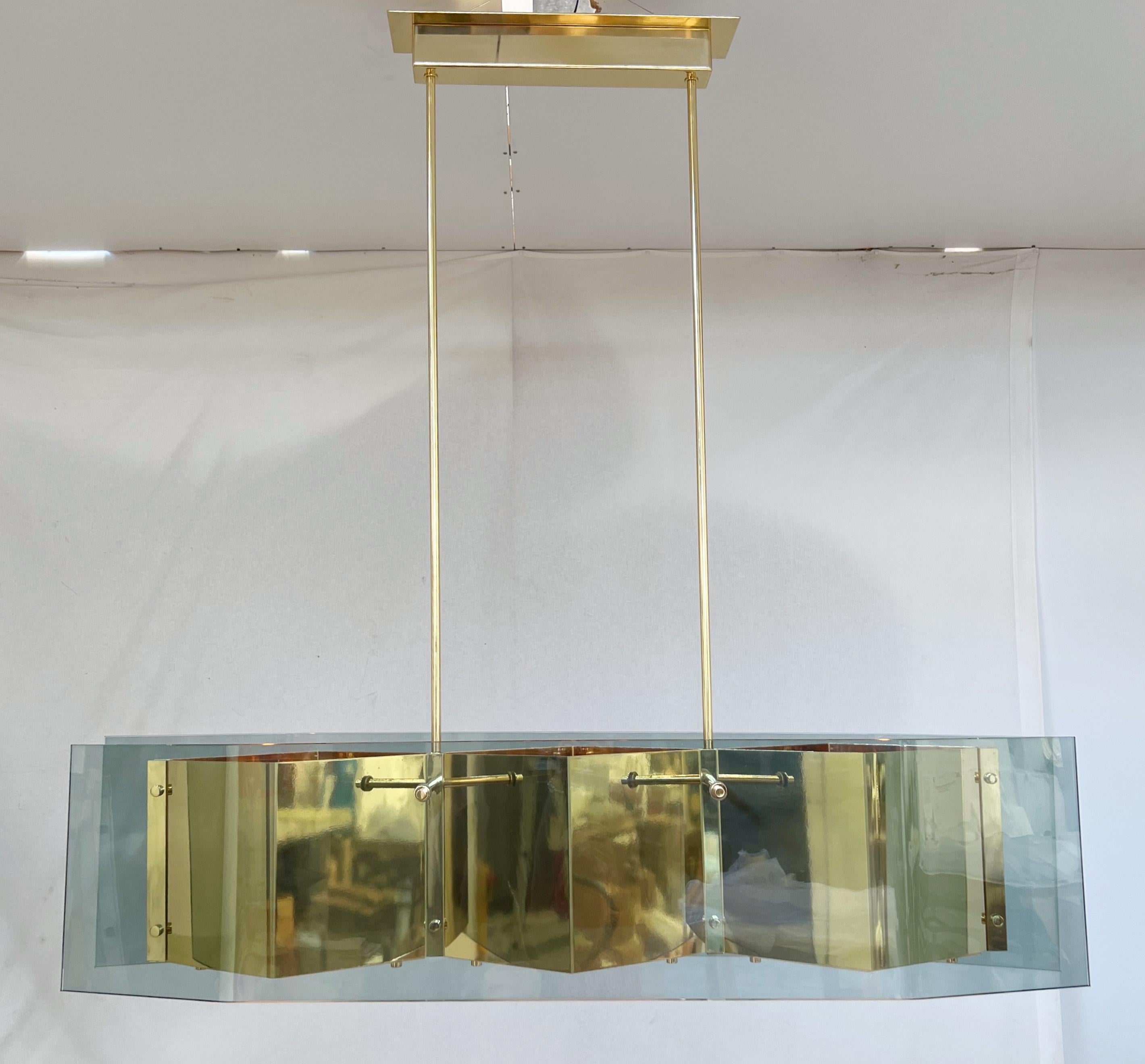 Italian modern chandelier with elongated light green glass panels mounted on polished brass frame with diamond shaped bottom glass diffusers / Made in Italy
Measures: width 52.5 inches / depth 10.5 inches / height 12.5 inches / total height 51