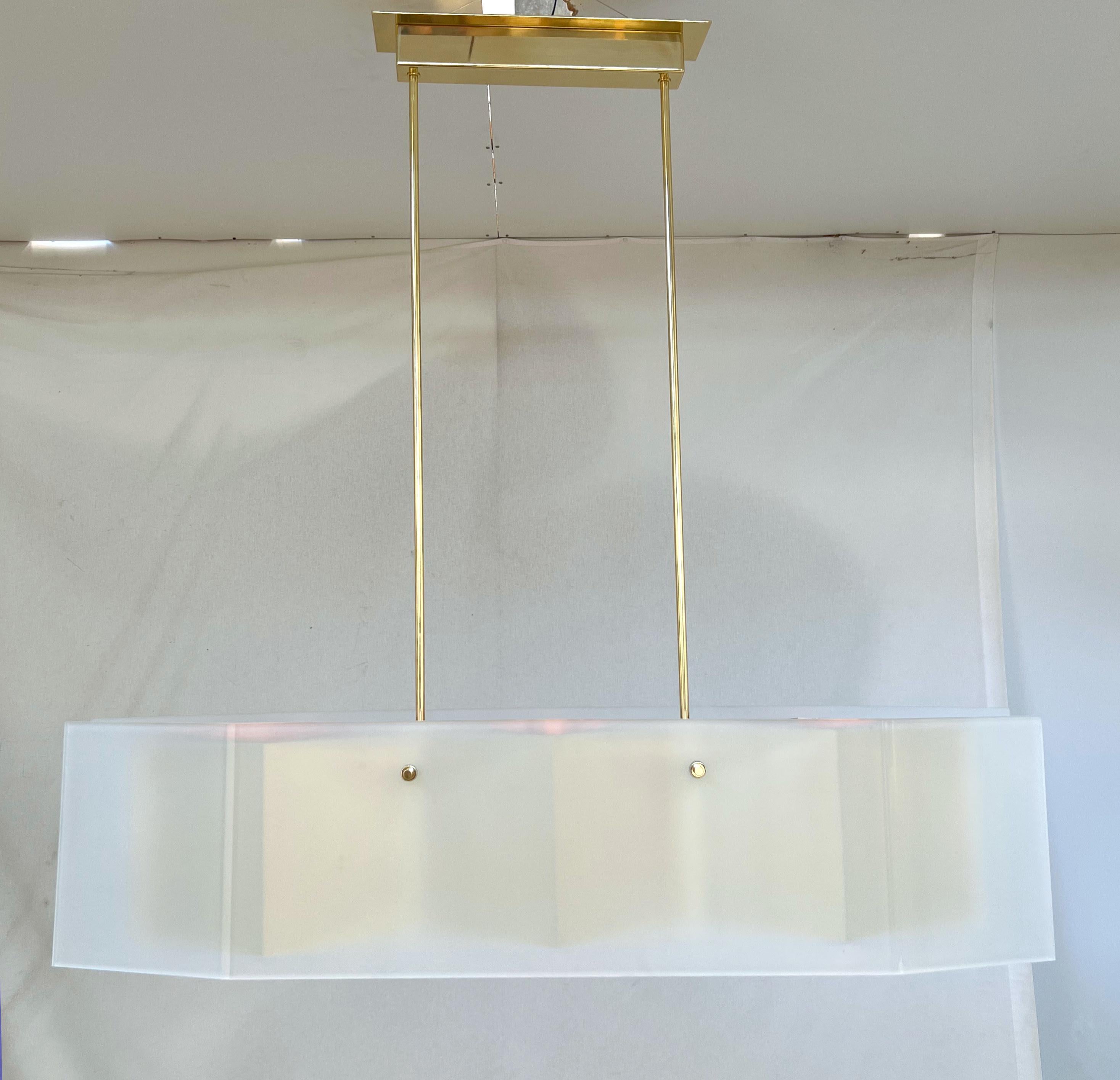 Italian modern chandelier with elongated frosted glass panels mounted on polished brass frame with diamond shaped bottom glass diffusers / Made in Italy
Measures: width 52.5 inches / depth 10.5 inches / height 12.5 inches / total height 51 inches
