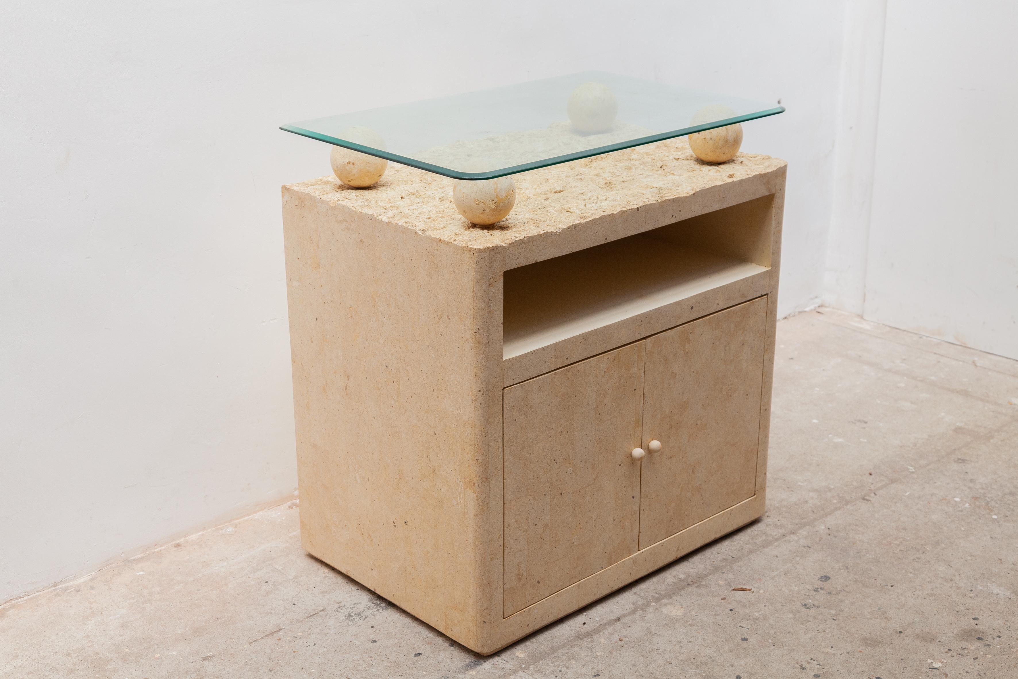 Minimalist design bar furniture by the Italian manufacture made in the '80s. The furniture is in a beautiful used vintage condition. A faux marble dry bar/cabinet with a faceted glass top for your wine bottles and glasses. This piece of furniture is