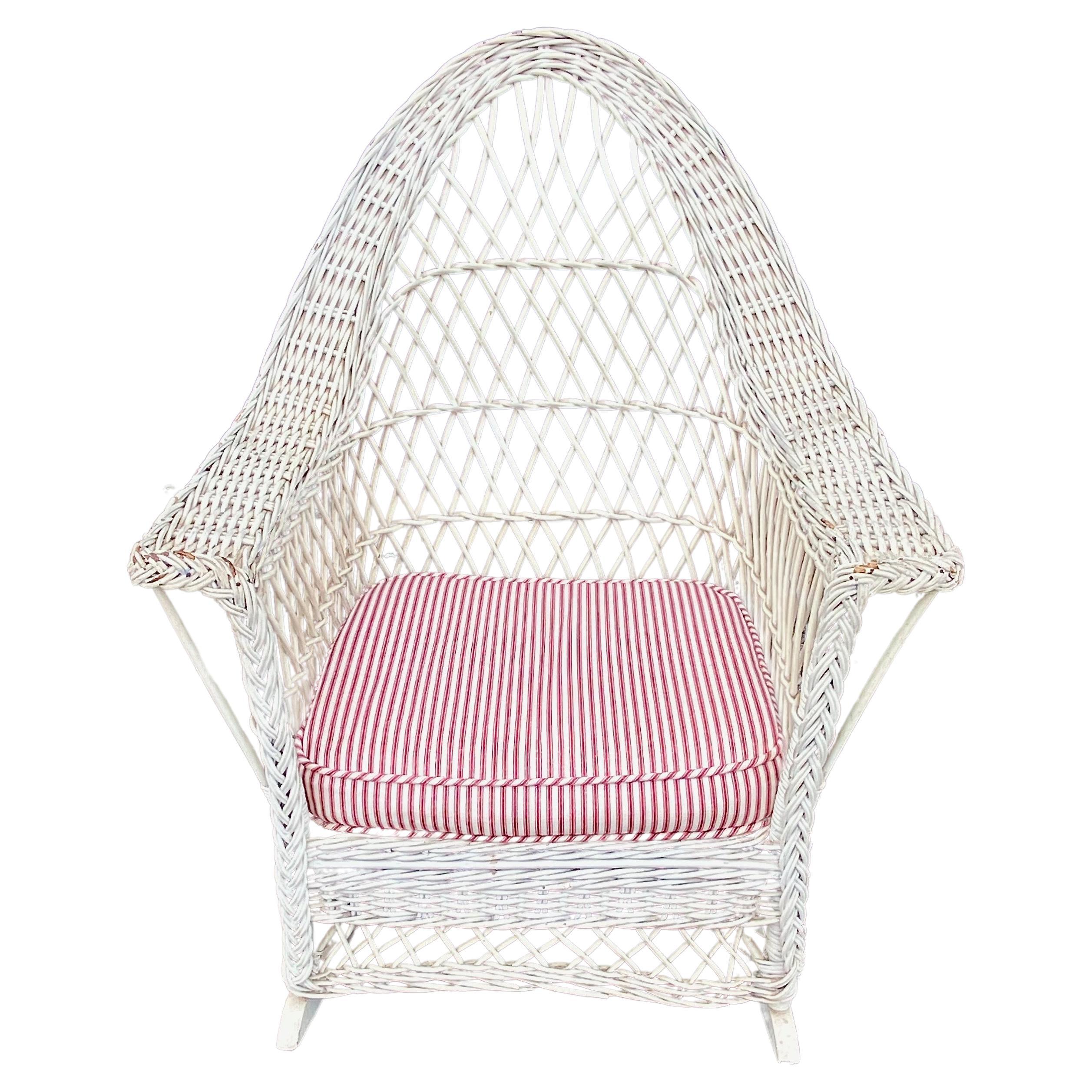 This is an unusual gothic-arched back Bar Harbor-style wicker rocking chair that fully embodies the current Coastal Style design aesthetic. The chair is fresh from a Beverly Hills estate and ready for another few generations of use. The chair is in